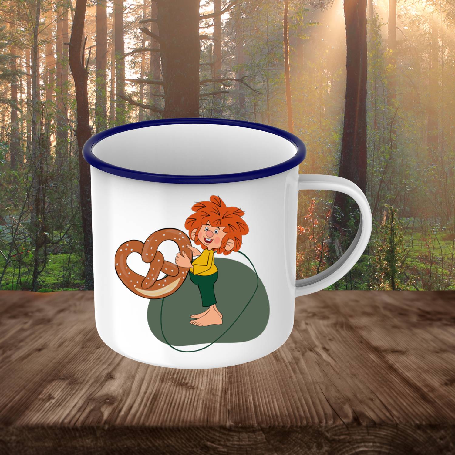 Pumuckl Emaille-Tasse "Breze" mit rothaarigem Kobold, der eine große Brezel hält, auf Holztisch stehend.