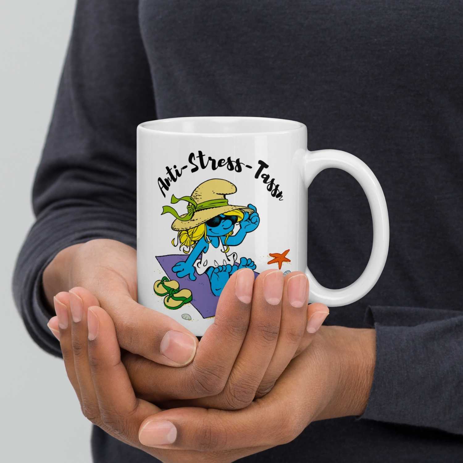 Weiße Schlümpfe Tasse Anti Stress Damen mit Schlumpfine am Strand, in Händen gehalten.