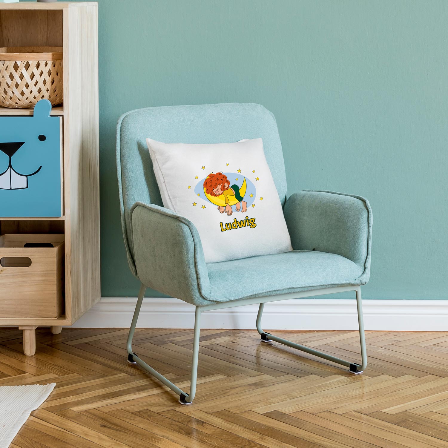 Personalisiertes Pumuckl Kuschelkissen mit Schlaf-Pumuckl auf dem Mond und individuellem Namen Ludwig auf mintfarbenem Sessel.