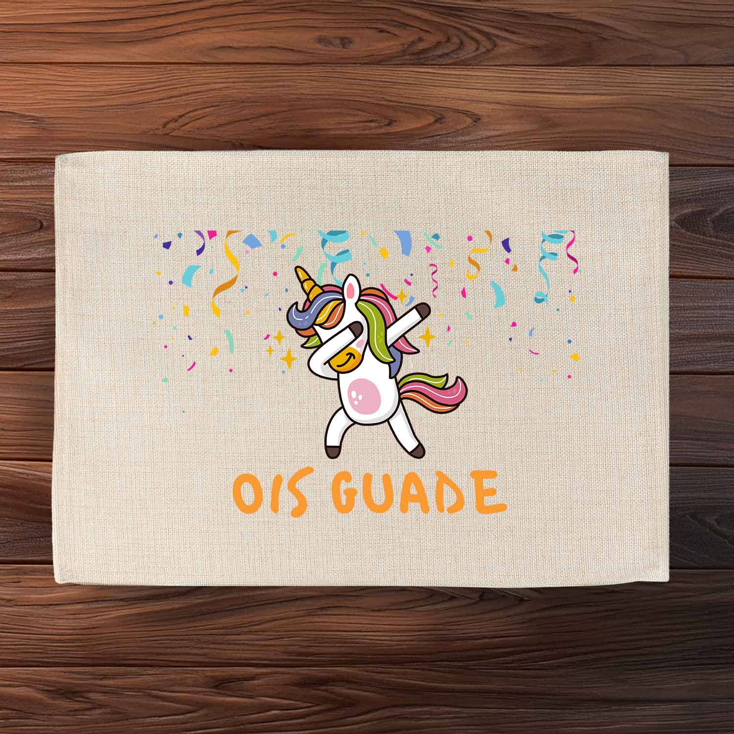 Tischset Ois Guade Einhorn mit dappendem Einhorn, Konfetti und buntem Schriftzug auf hellem Stoff.
