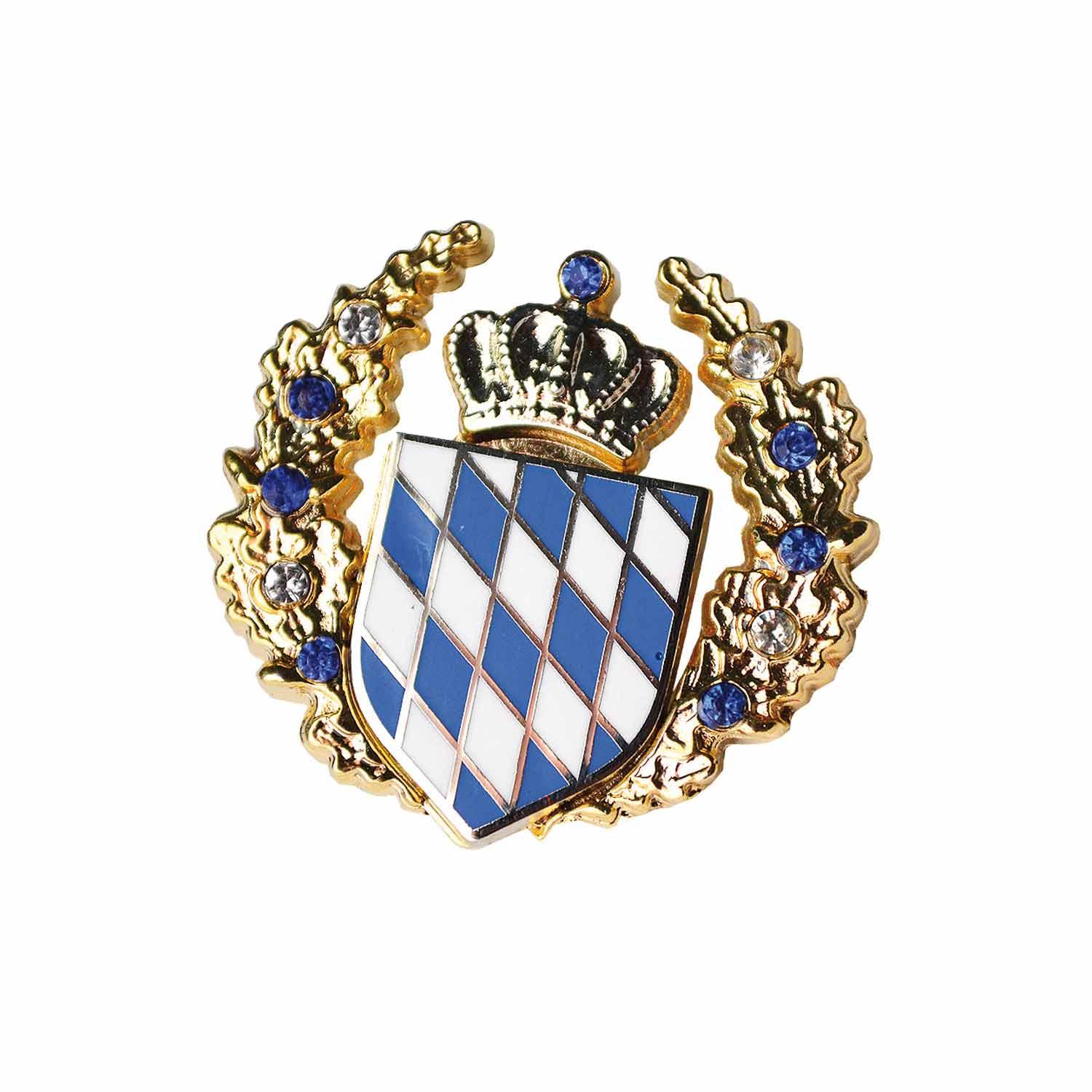 Goldfarbenes Anstecker-Abzeichen mit weiß-blauem Rautenmuster und Krone, umrahmt von einem Kranz mit blauen und transparenten Steinen