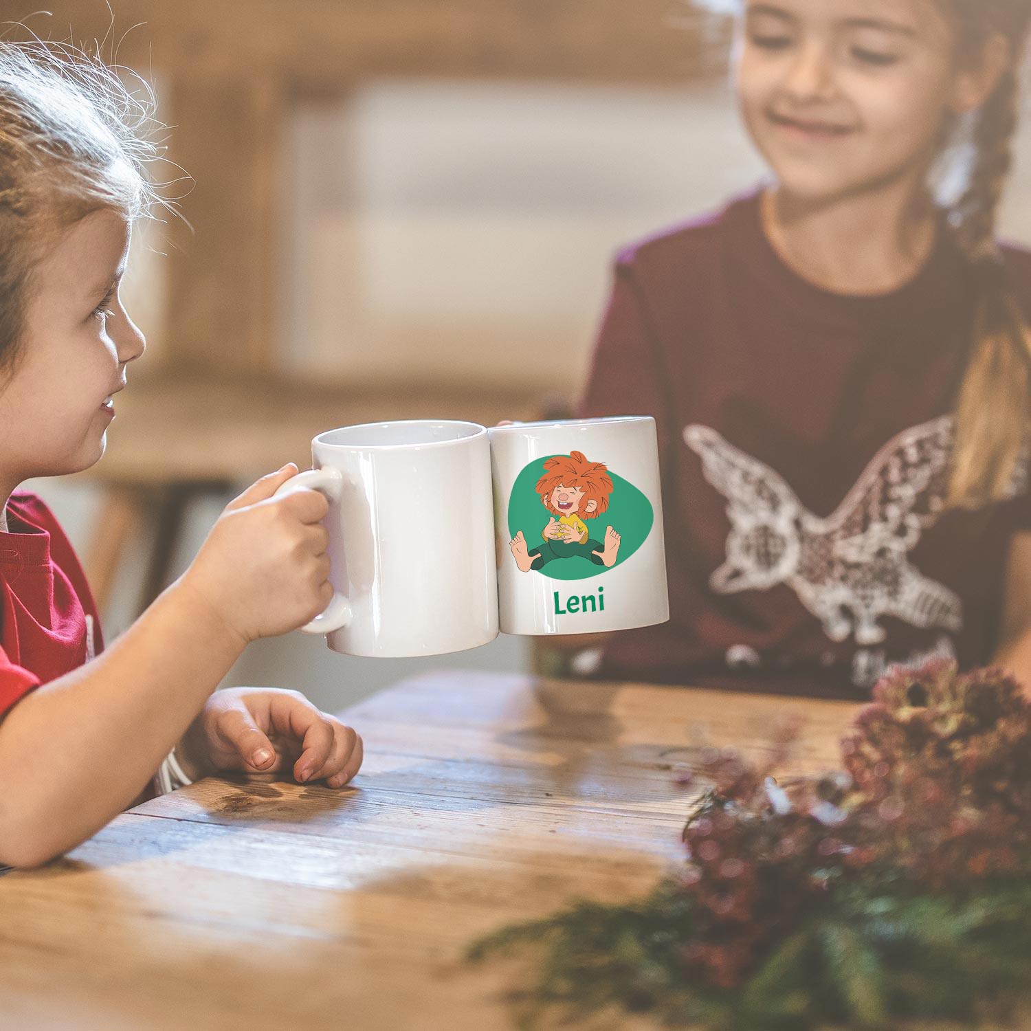 Zwei Kinder teilen eine persönliche Pumuckl Tasse mit Wunschname Leni auf einem Holztisch.