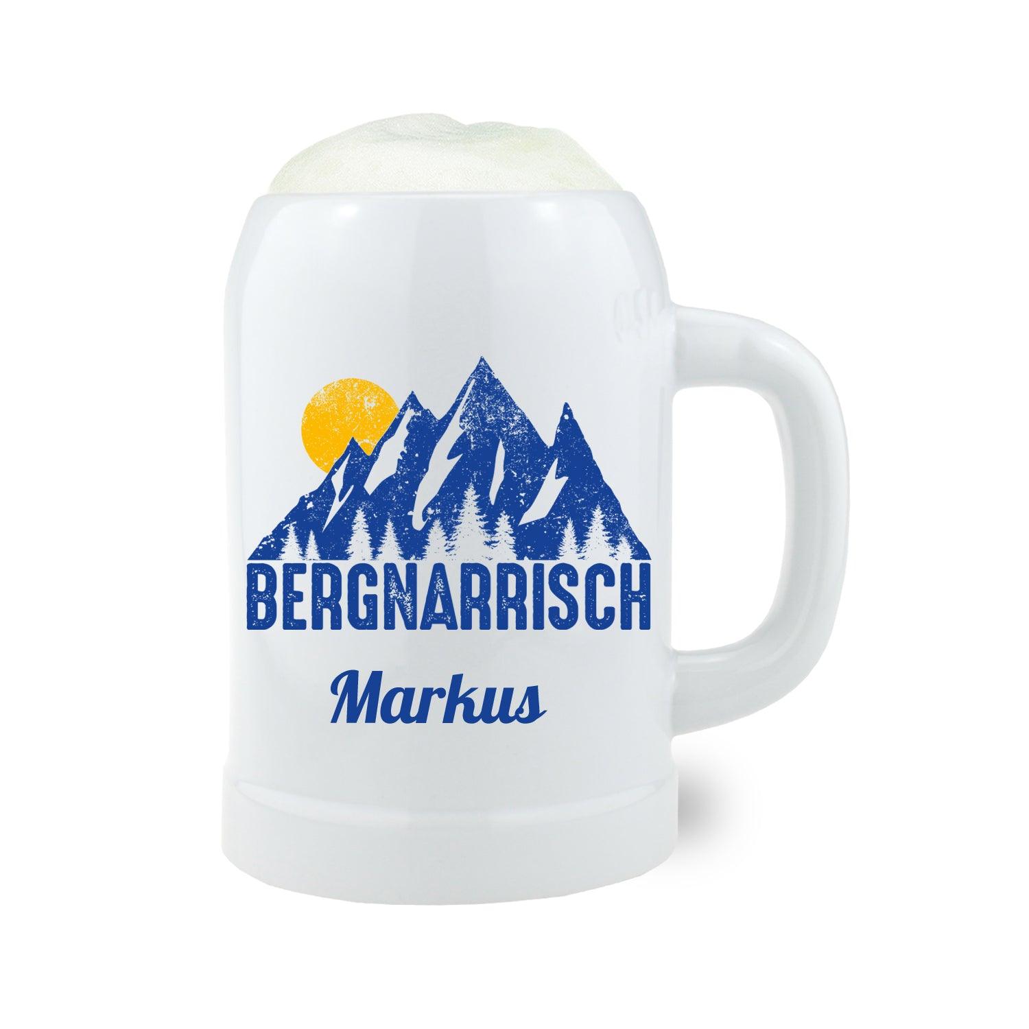Weißer Bierkrug Bergnarrisch blau mit Wunschname Markus, Bergsilhouette und Sonne, gefüllt mit Schaum.