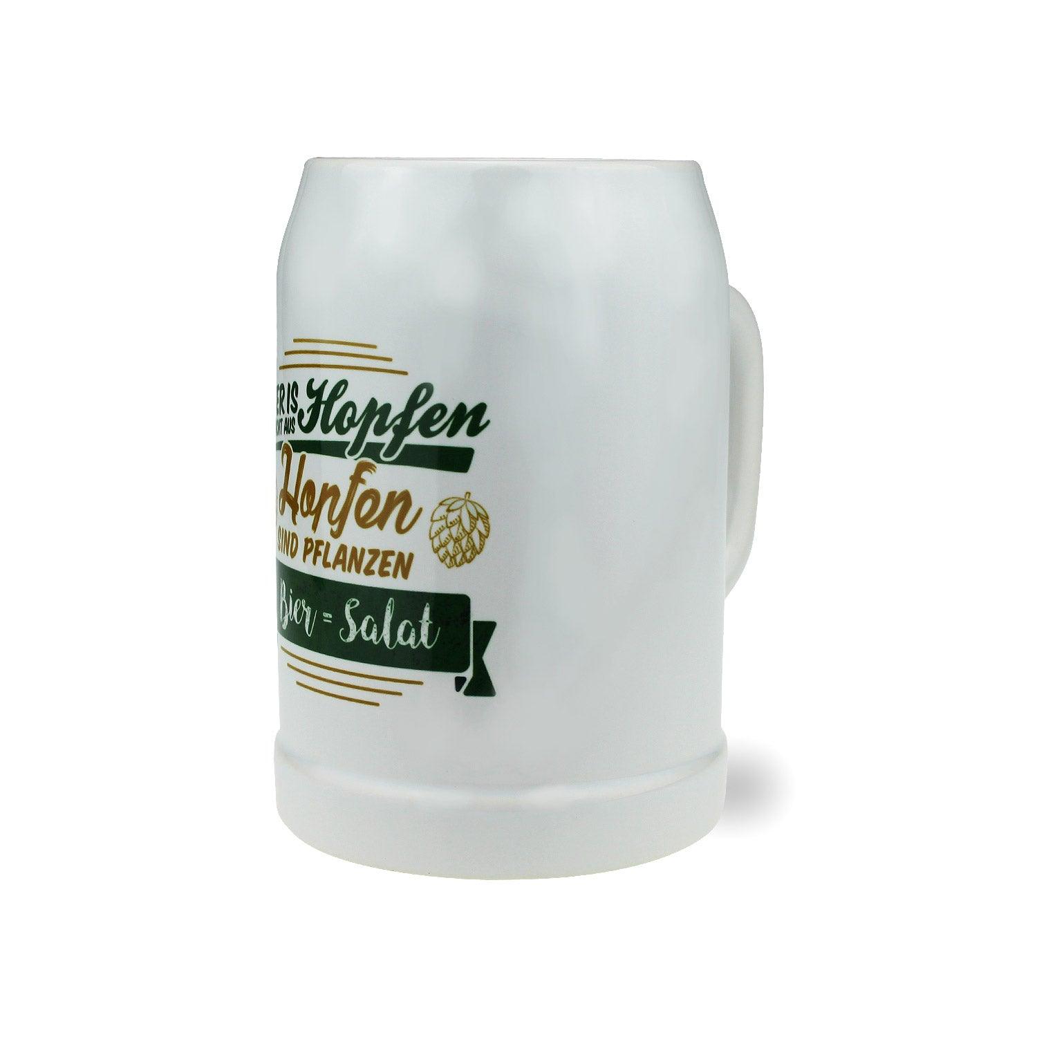 Klarer Bierkrug aus Glas mit schwarzem Aufdruck „Bier = Salat“ und bayerischen Symbolen, 0,5 l, 126 mm hoch.