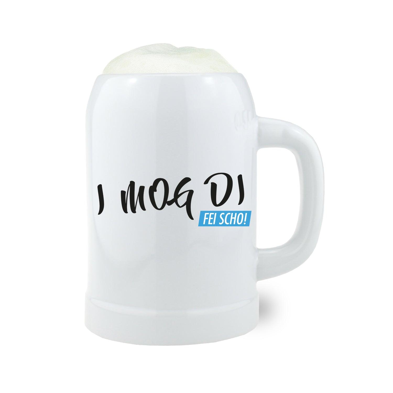 Bierkrug I mog di fei scho mit spritziger Schaumkrone, weißem Design und schwarzem Schriftzug