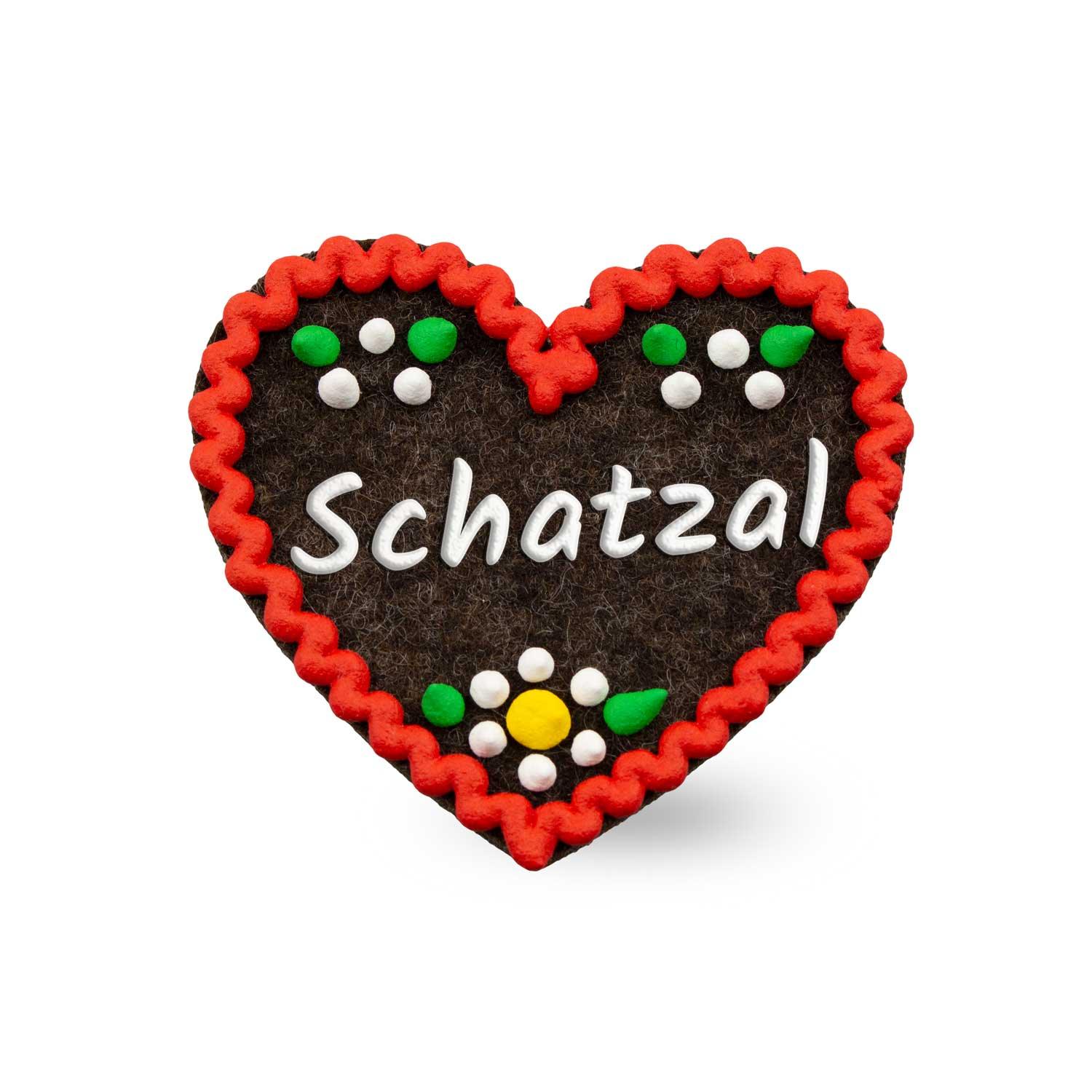 Brauner Filzherz-Anstecker "Schatzal" mit rotem Zickzackrand und weißen sowie bunten Blumenverzierungen.