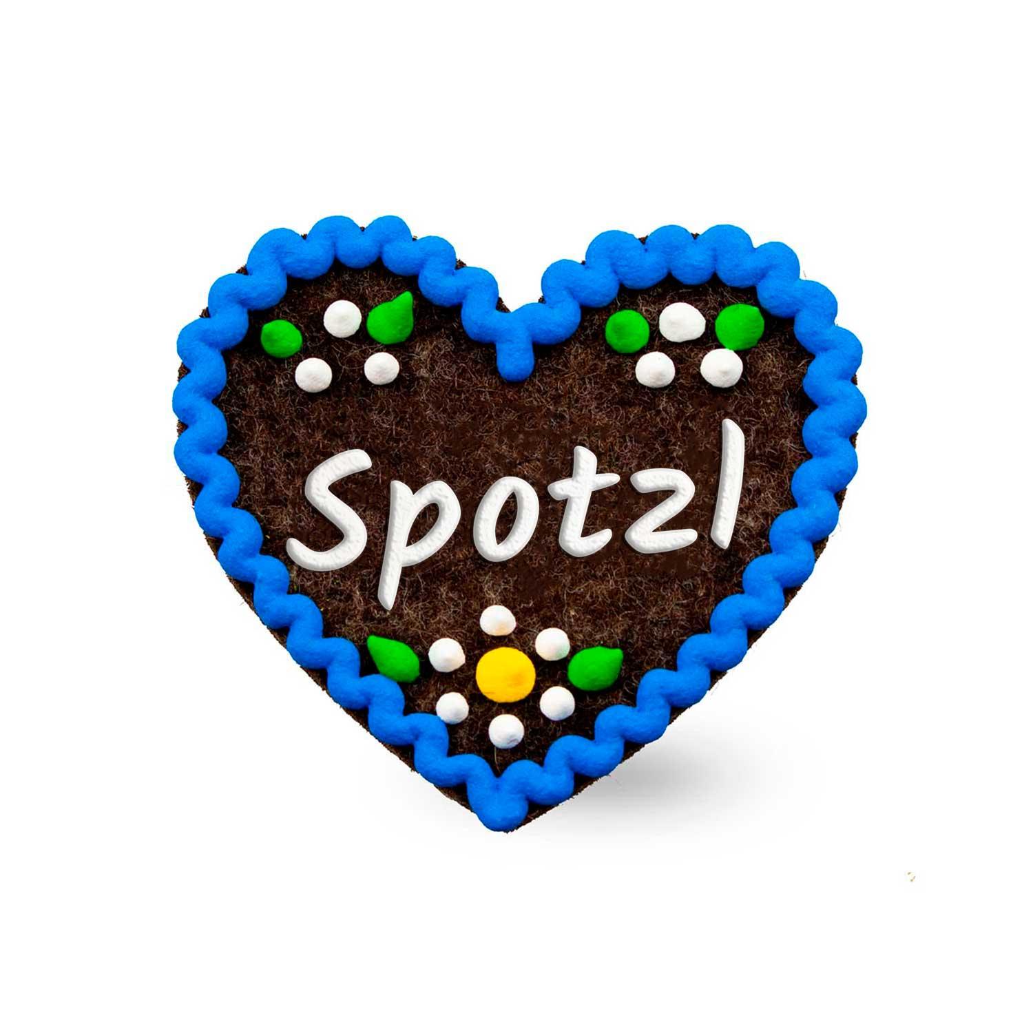 Brauner Filzherz-Anstecker Spotzl mit blauem Rand, weißer Schrift und bunten Punkten verziert auf weißem Hintergrund.