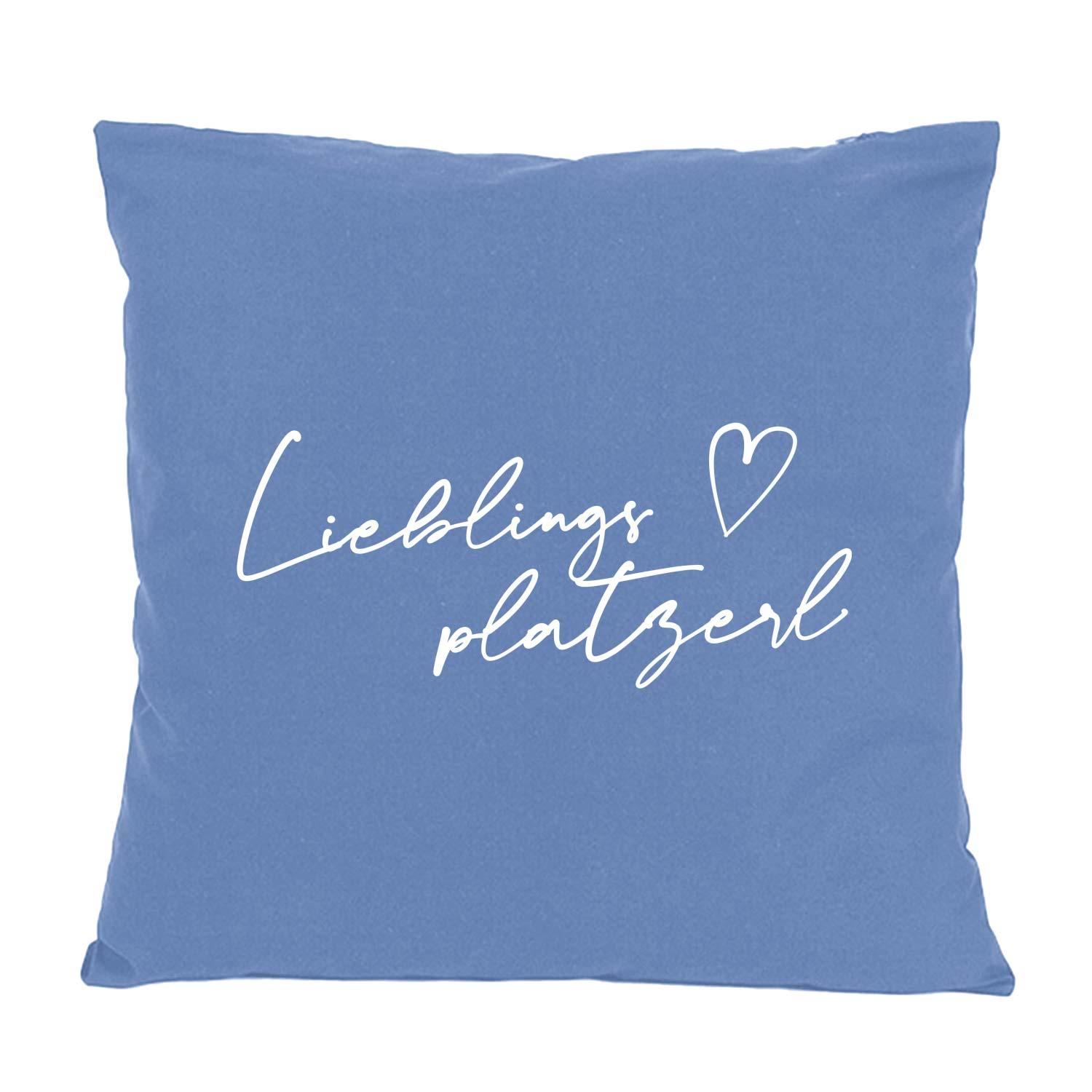 Blaues Kissen "Lieblingsplatzerl" mit weißer geschwungener Schrift und Herz, quadratisch, weich.