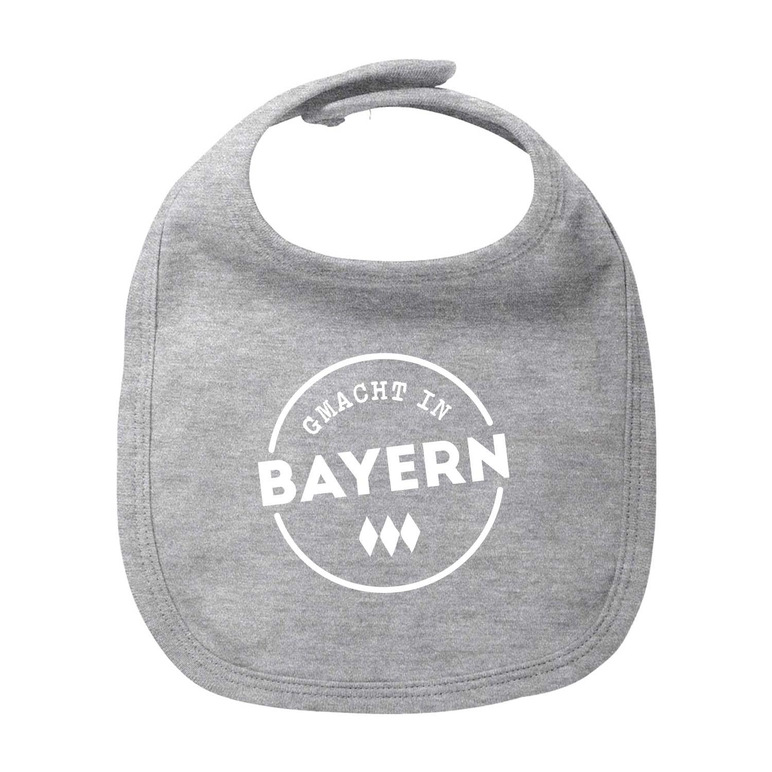 Graues Lätzchen Gmacht in Bayern für Babys mit weißem Logo und bayerischem Rautenmuster.