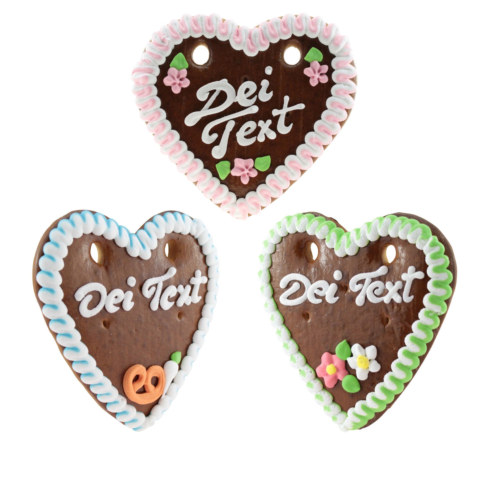 Drei verzierte Lebkuchenherzen mit individuellen Sprüchen, bunten Randverzierungen und kleinen Blumen oder Brezeln.