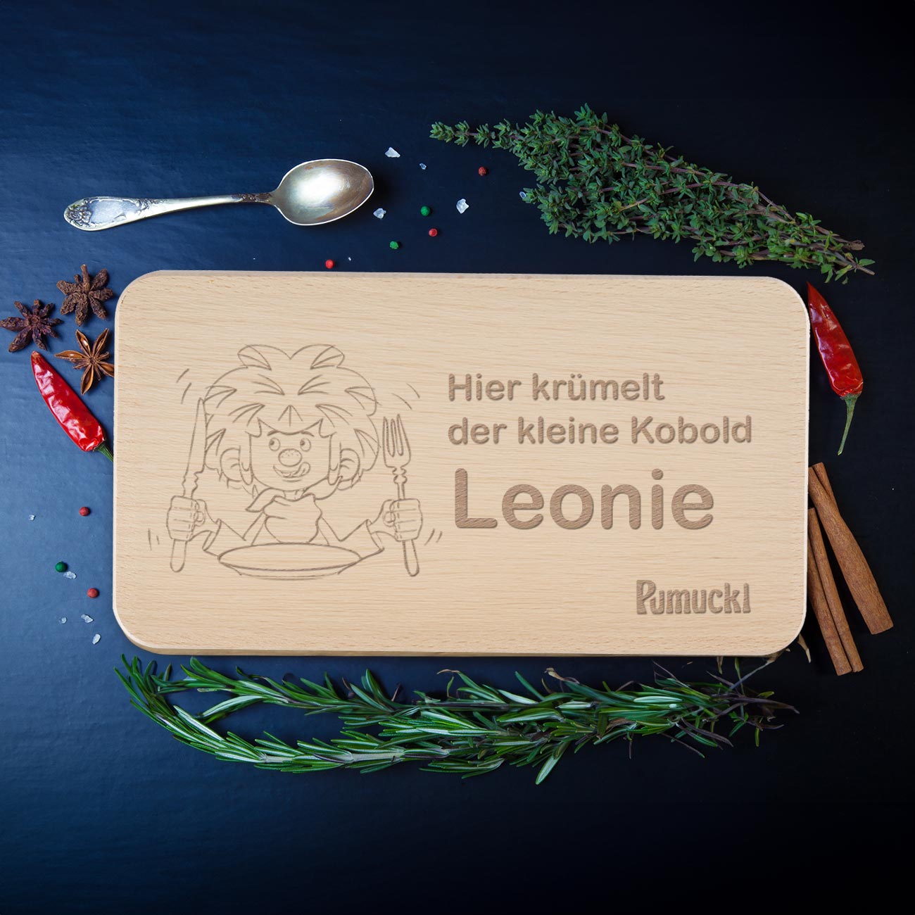 Pumuckl Frühstücksbrett aus Holz mit Wunschname Leonie, Lasergravur vom Kobold, umgeben von Kräutern.