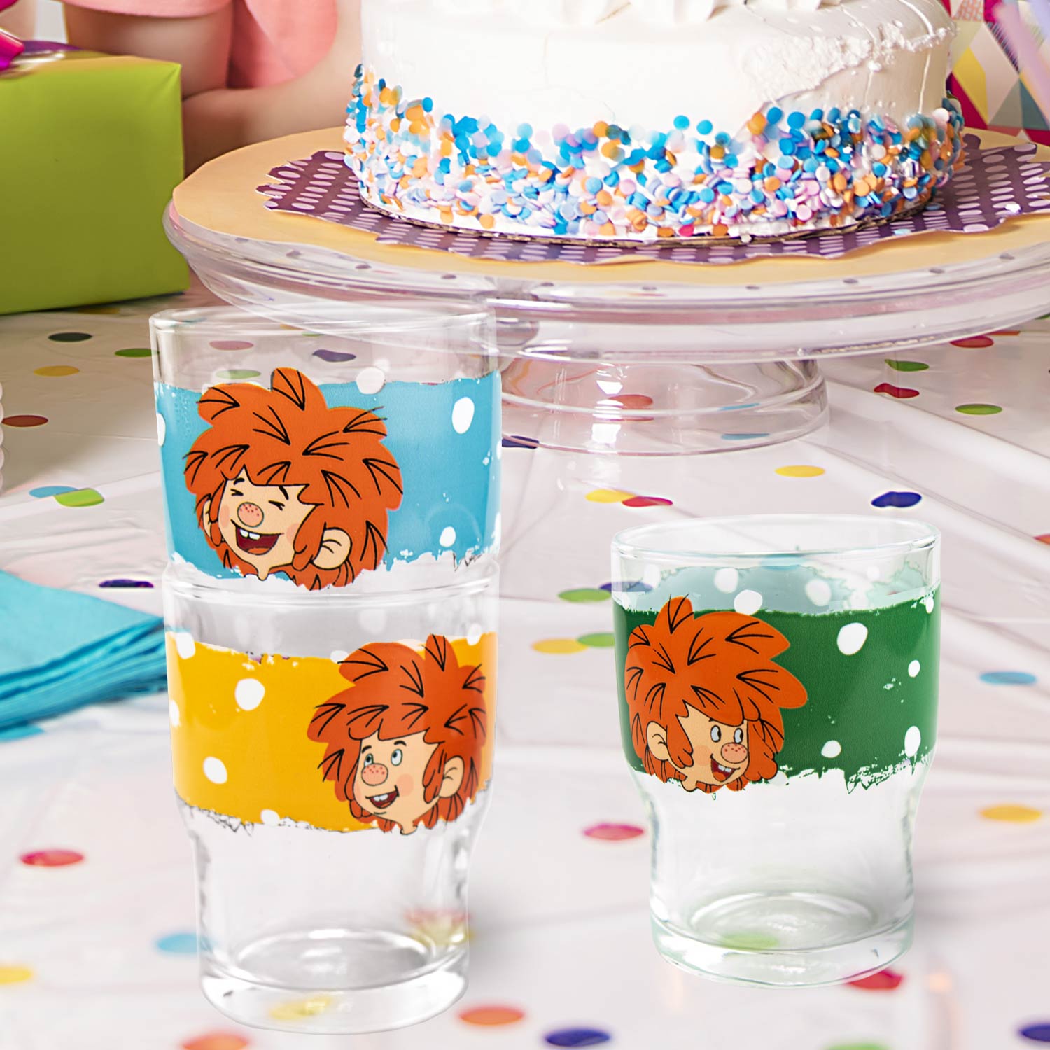 Pumuckl Kinder Trinkglasset: drei bunte Gläser mit Pumuckl-Motiv auf festlich geschmücktem Tisch mit Kuchen