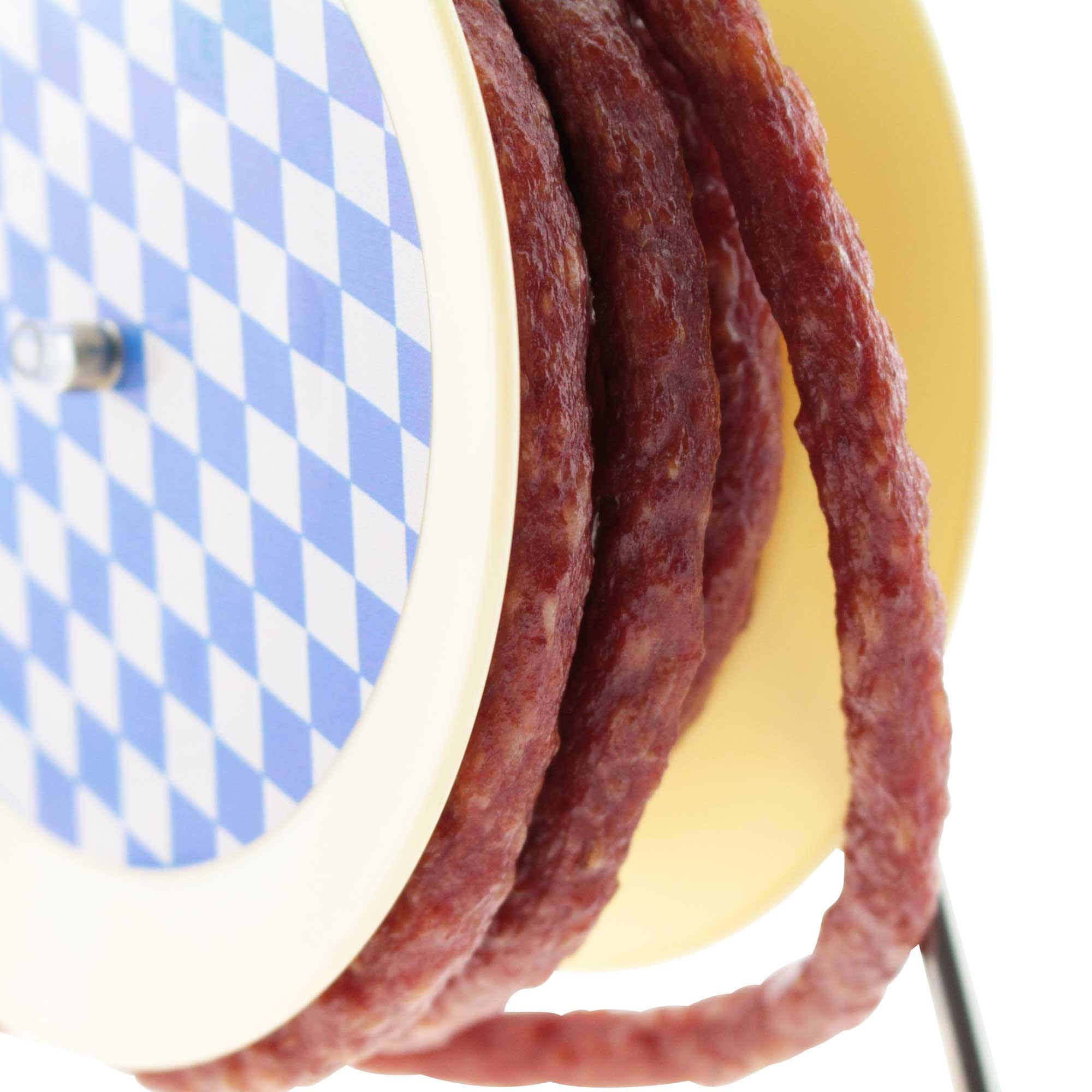 Bayrische Kaminwurzen auf einem runden Teller mit hellblau-weißem Rautenmuster.