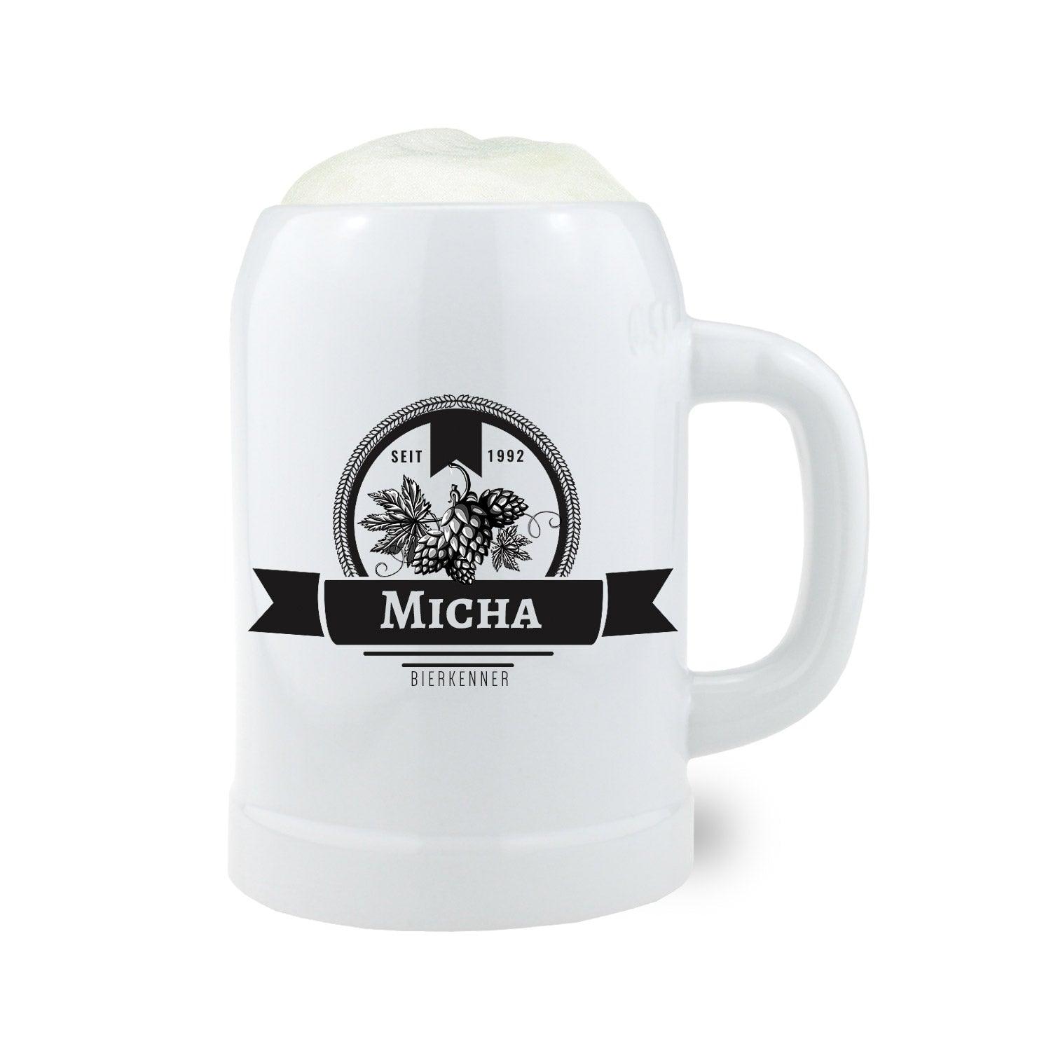 Weißer Bierkrug mit personalisiertem Namen "Micha" und Hopfenmotiv, gefüllt mit frischem Bierschaum.