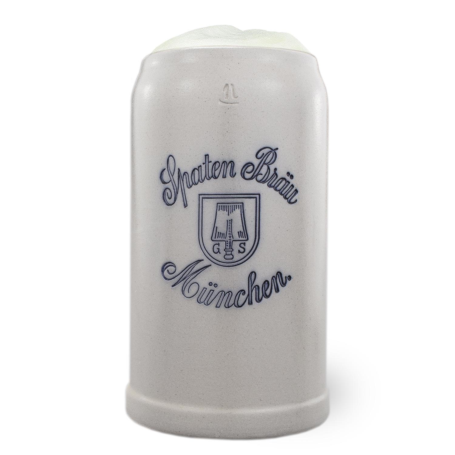 Grauer, traditioneller Stein Bierkrug 1 Liter mit Schaum, weißem Spaten Bräu München Logo und Emblem.