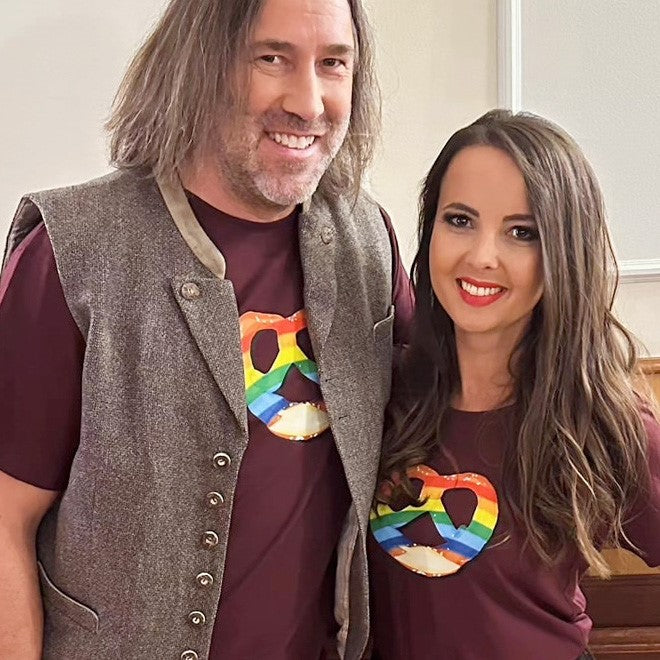 Paar präsentiert das Herren T-Shirt Regenbogen-Brezn mit stylischem grauem Janker und lächelnden Gesichtern.