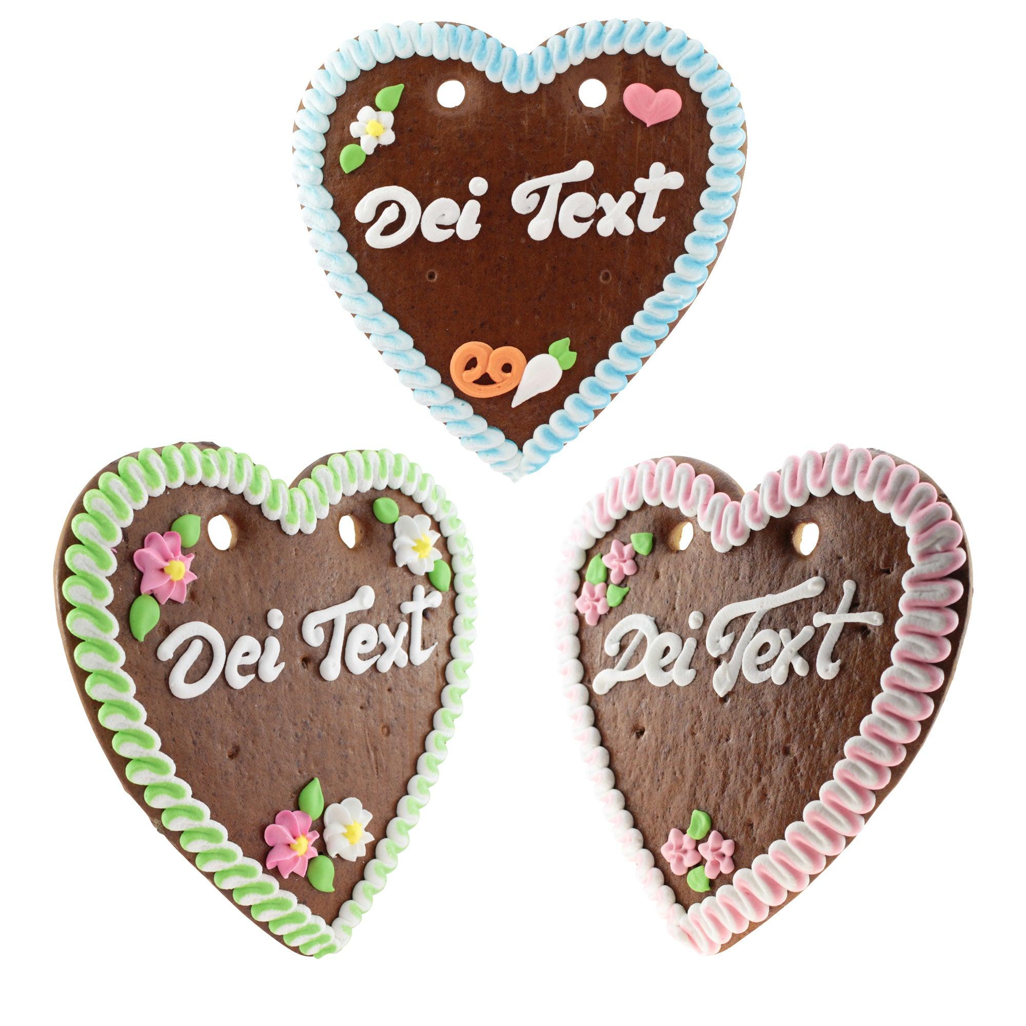 Drei Lebkuchenherzen mit individueller Beschriftung, bunter Zuckerguss-Verzierungen und Blumen-Dekor.