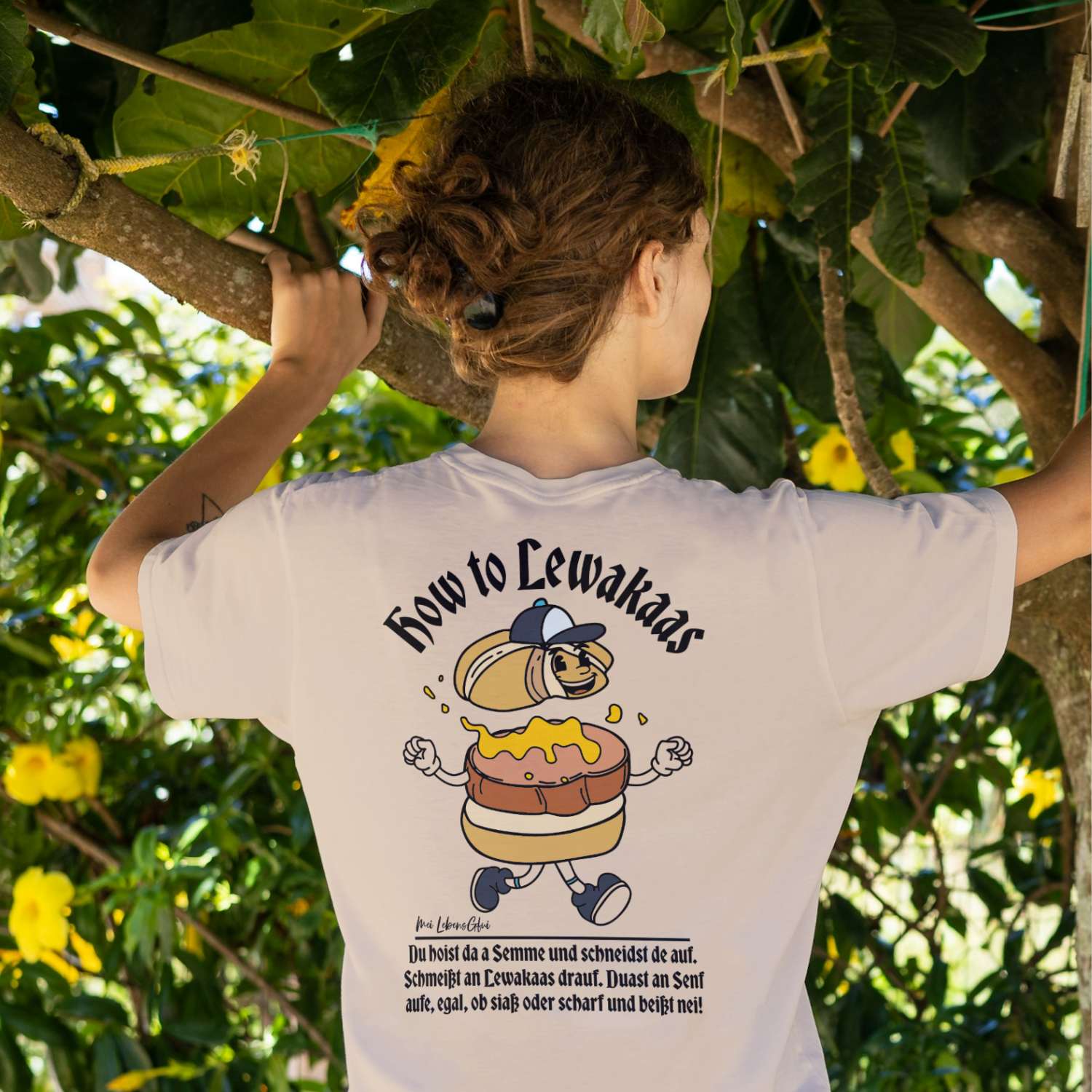 Rückenansicht einer Frau im weißen Damen Rezept T-Shirt "Lewakaas", mit bayerischem Spruch und gelber Grafikaxt.