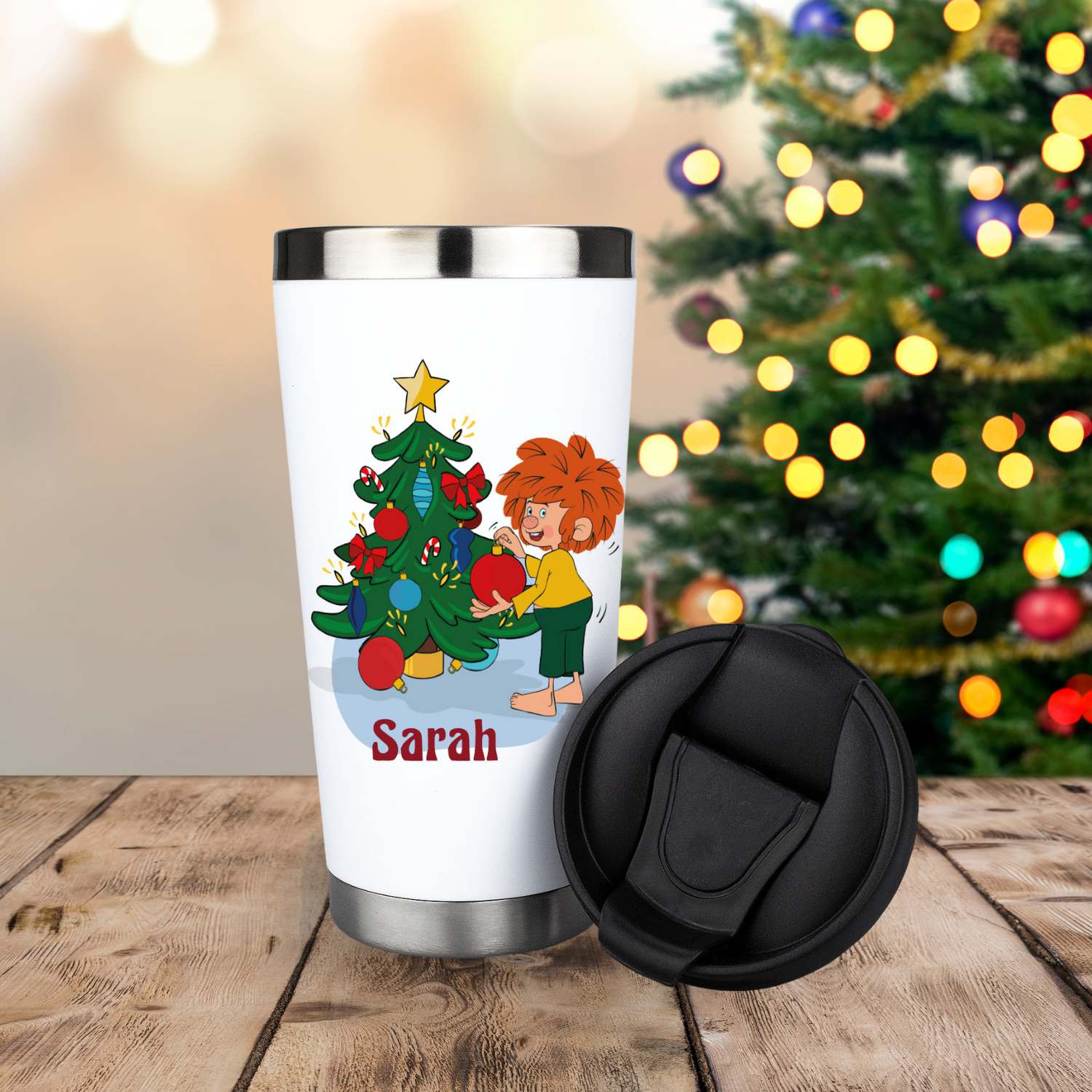 Pumuckl Thermo-Becher Weihnachten personalisierbar mit Pumuckl am Weihnachtsbaum, auf Holztisch vor Lichterkette
