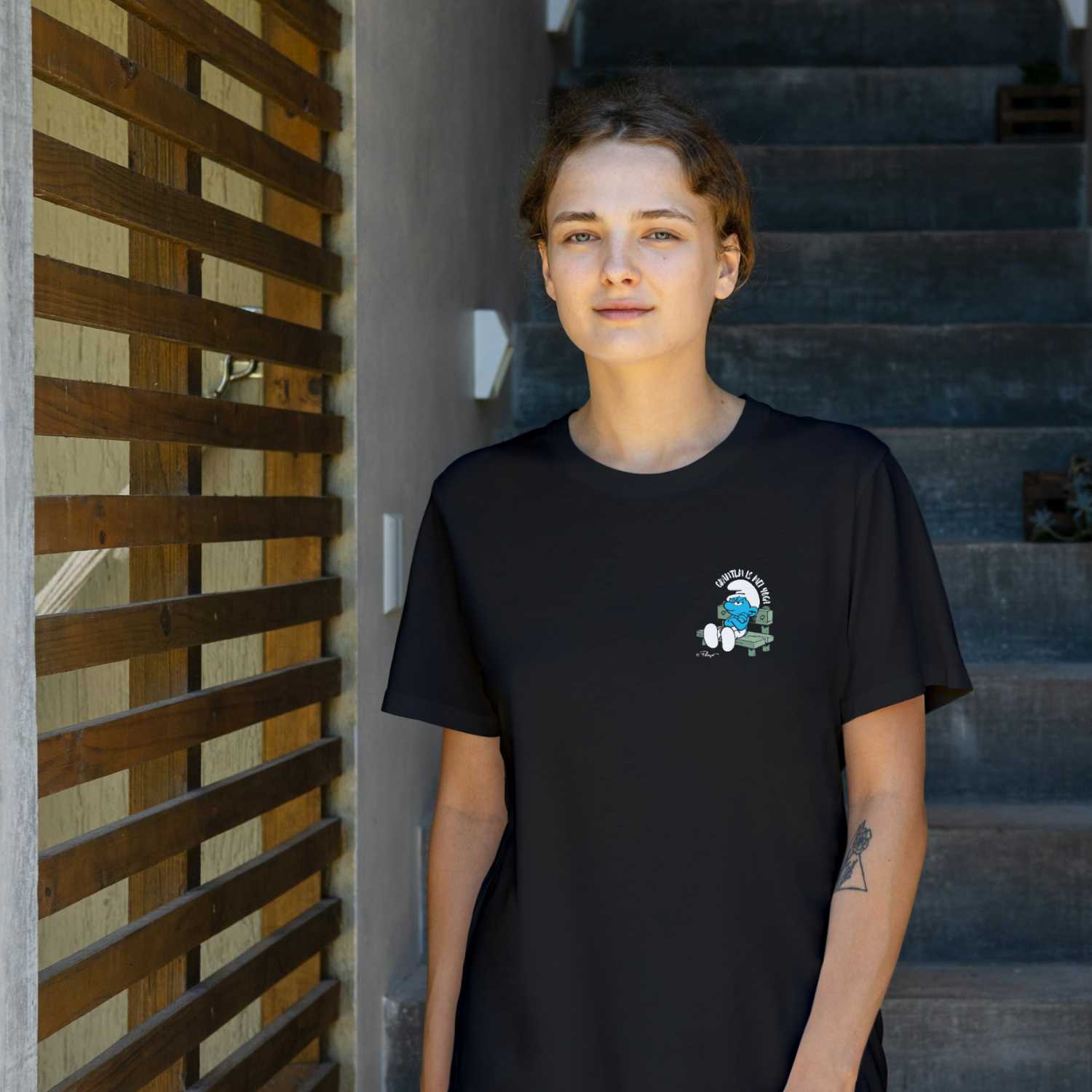 Damen T-Shirt mit grantelndem Schlumpf auf Bank und "Grantln is mei Yoga" Schriftzug in Schwarz.