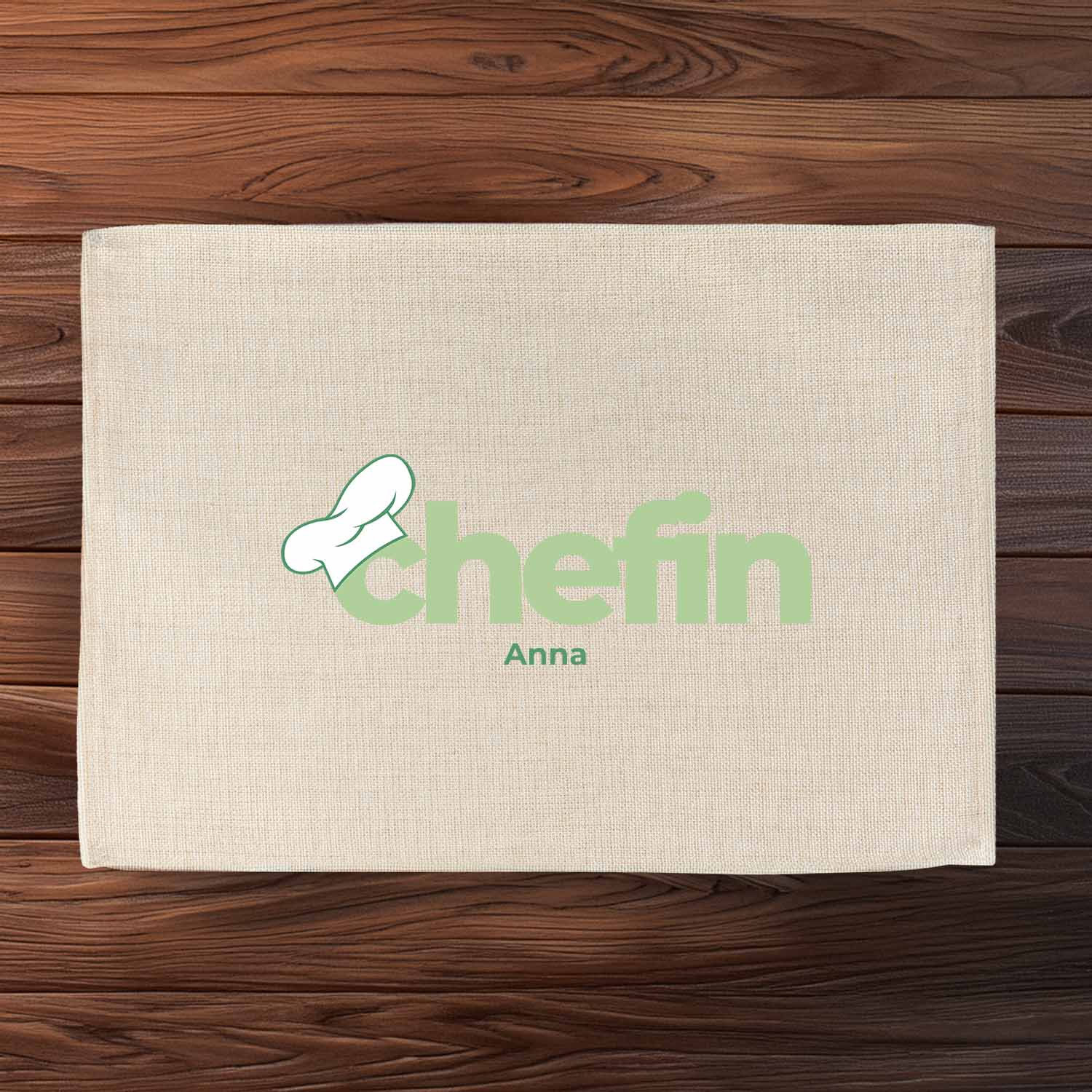 Tischset "Chefin" mit eingedrucktem Namen Anna und Kochmütze in Grün auf naturfarbenem Stoff.