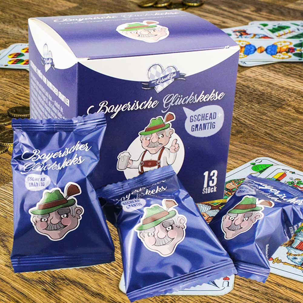 Bayerische Glückskekse in lila-farbener Geschenkbox und einzeln verpackten Beuteln auf Holztisch