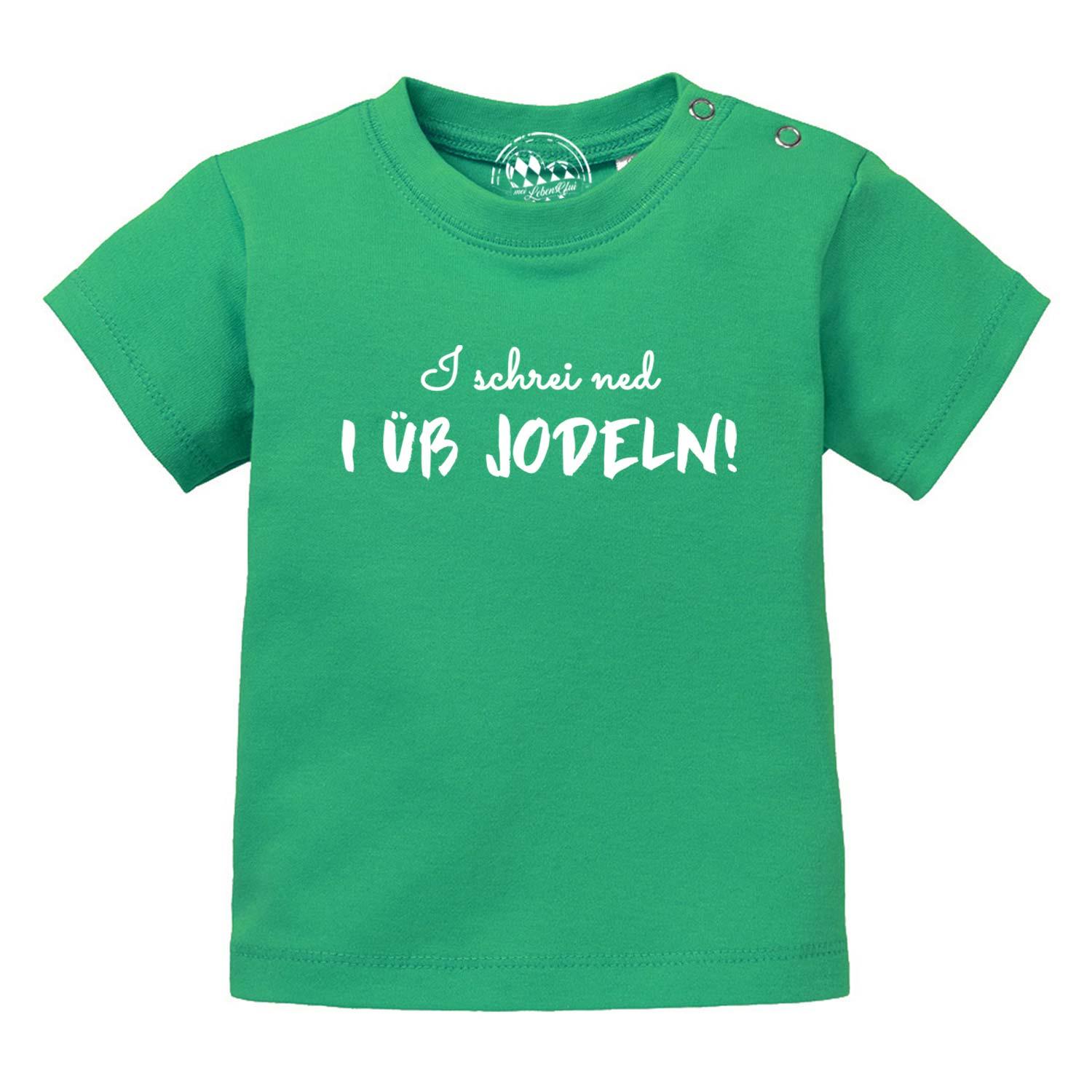 Grünes Baby T-Shirt I üb jodeln mit weißer Aufschrift und Druckknöpfen an der Schulter für einfaches Anziehen.