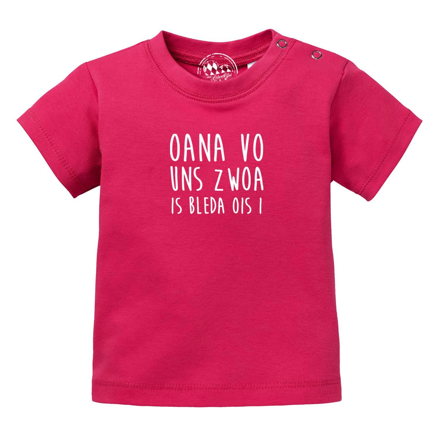 Pinkes Baby T-Shirt "Bleda ois i!" mit weißem Spruch und Druckknöpfen an der Schulter.