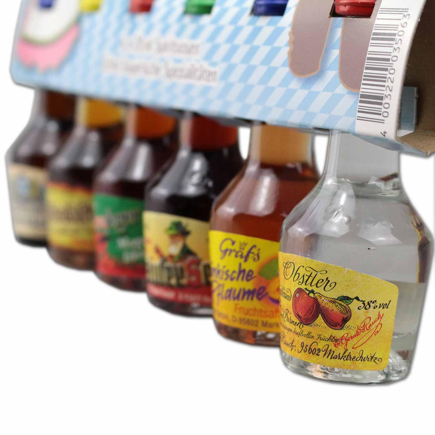 Reihe von sechs farbenfrohen bayerischen Likör-Miniaturflaschen mit Obstler und Pflaumenschnaps.