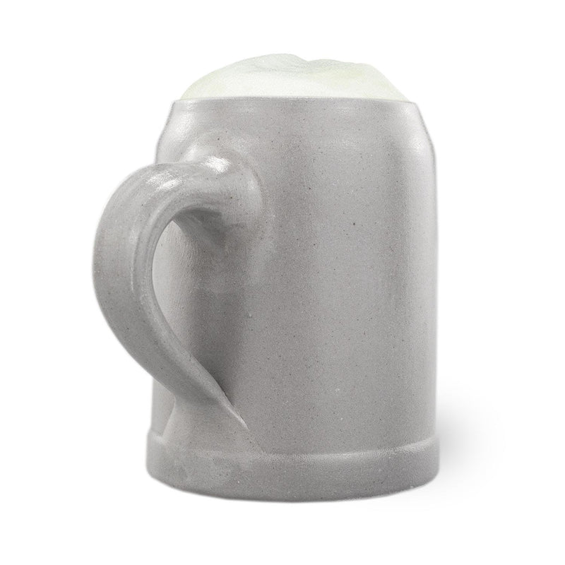 Grauer PREMIUM Bierkrug Edelweiß aus Keramik mit Henkel und Schaumkrone, Details der rauen Oberfläche sichtbar.