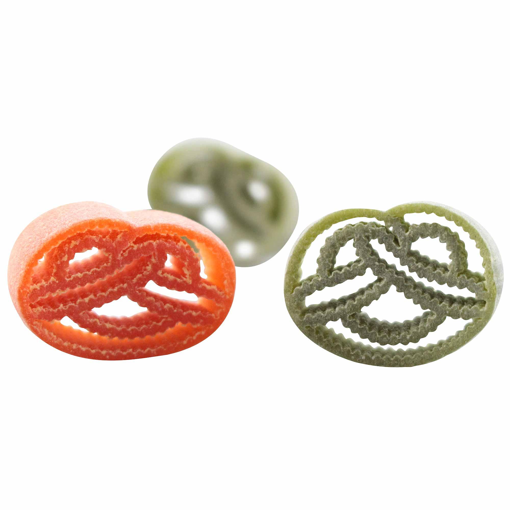 Runde, bunte Pretzel-Nudeln in Orange und Grün, teilweise transparent mit gemusterten Details, auf Weiß.