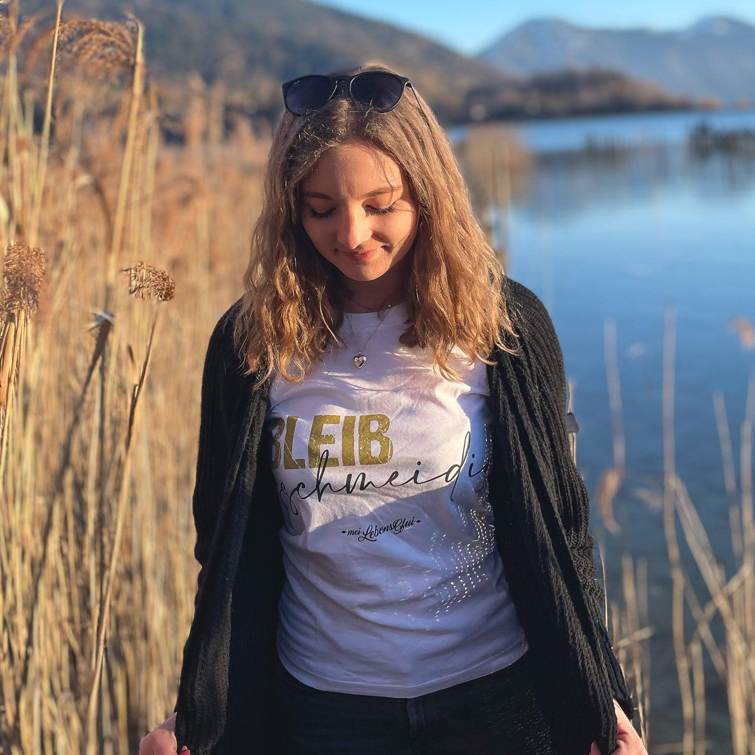Tragendes Modell in weißem Bleib gschmeidig Damen T-Shirt mit Aufdruck am Seeufer, umgeben von Schilf.