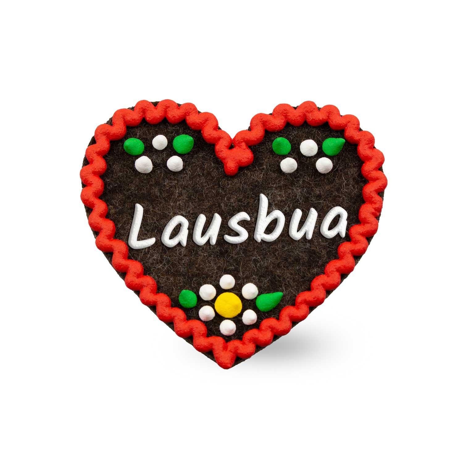 Brauner Filzherz-Anstecker "Lausbua" mit rotem Zierrand und bunten Blumen- sowie Punktmotiven.