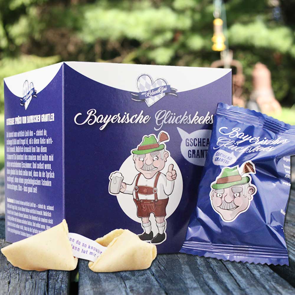Geschenkbox Bayerische Glückskekse mit bayerischem Spruch, verpacktem Keks und offener Glückskeks-Hälfte.