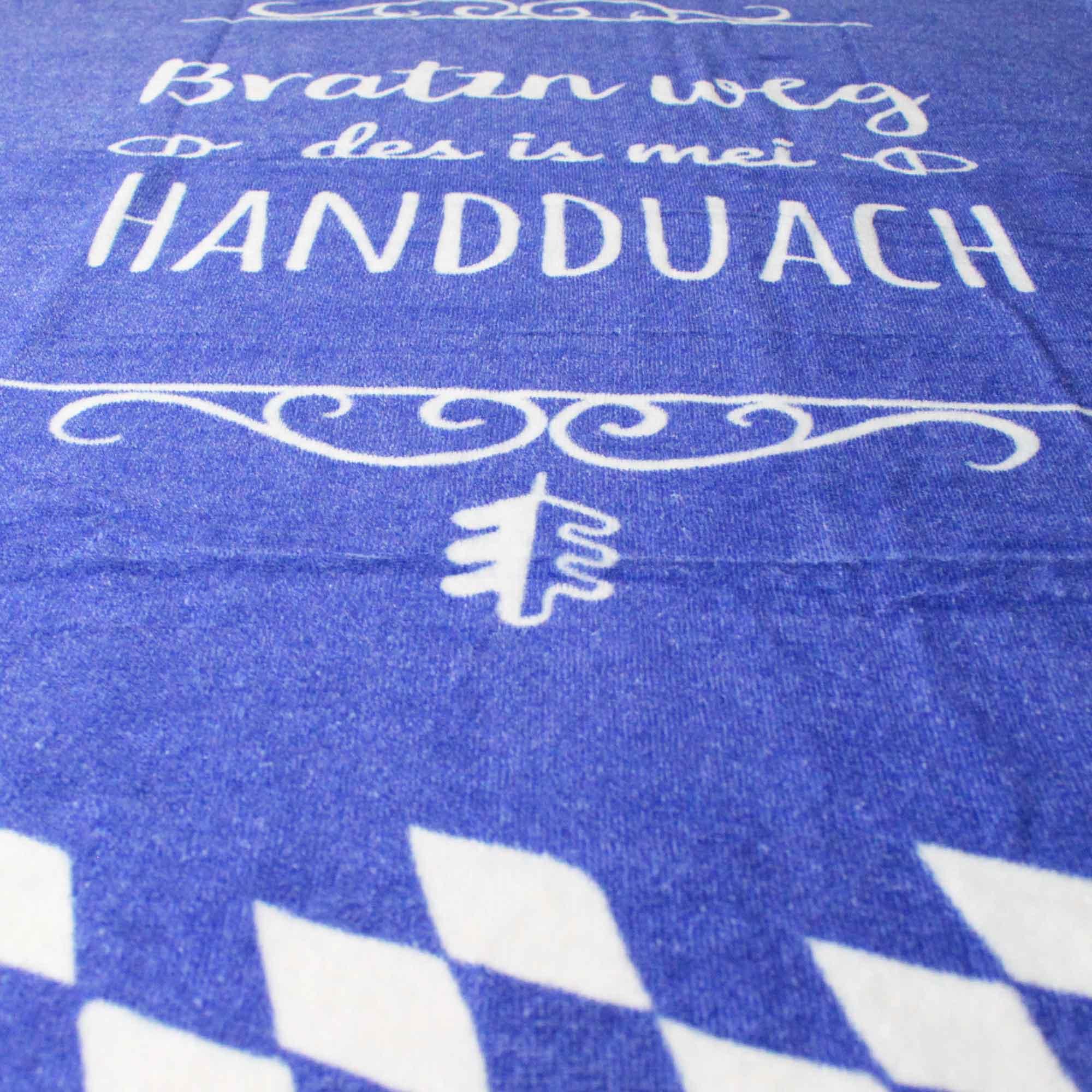 Blaues Handtuch mit bayerischer weiß-blauer Raute, stilvollen Verzierungen und lustigem Spruch in weißer Schrift.