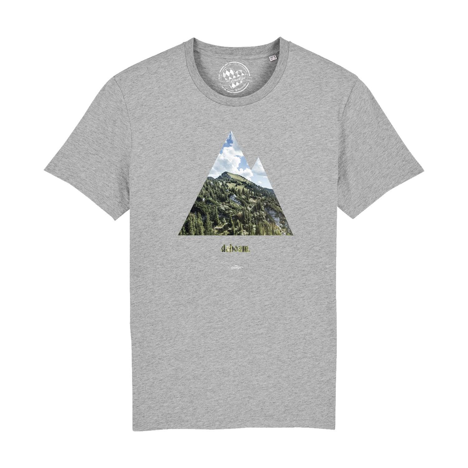 Graues Herren T-Shirt dahoam mit Bergmotiv, Nadelbäumen und blauem Himmel.