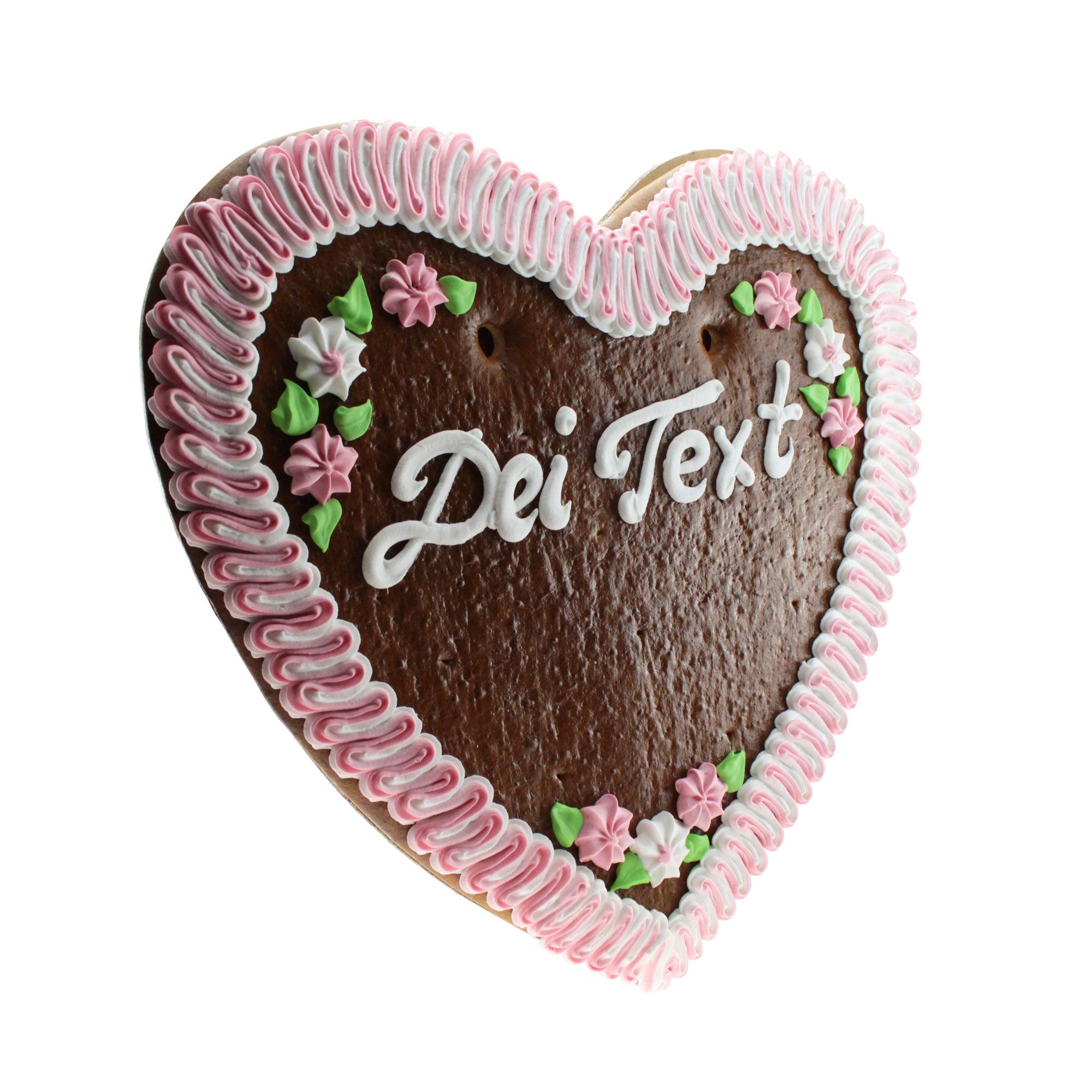 Lebkuchenherz mit rosa-weißem Zuckergussrand und individuellem Schriftzug in weißer Schrift auf braunem Zuckerguss.