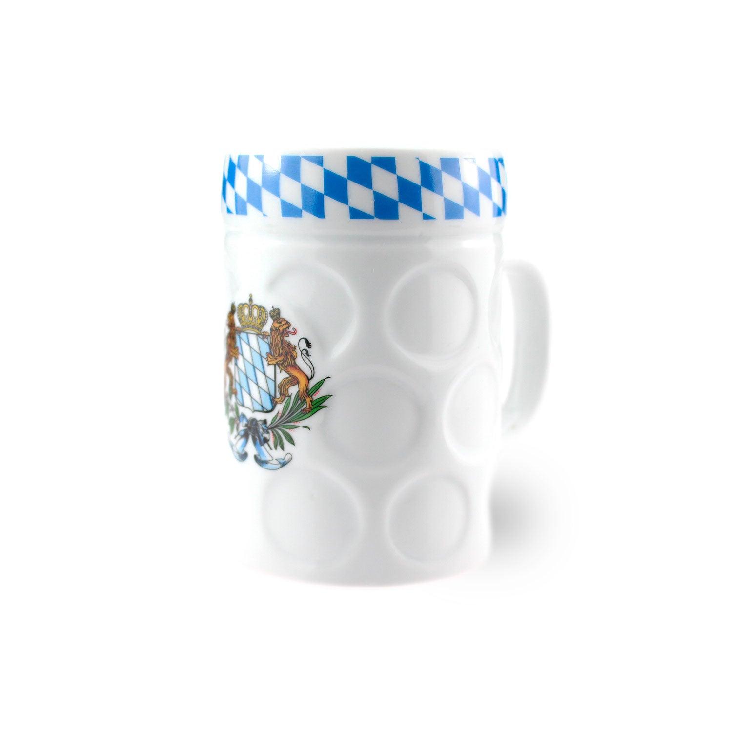 Weißer Bierkrug mit bayerischem Wappen sowie blau-weißem Rautenmuster oben und Noppenstruktur.