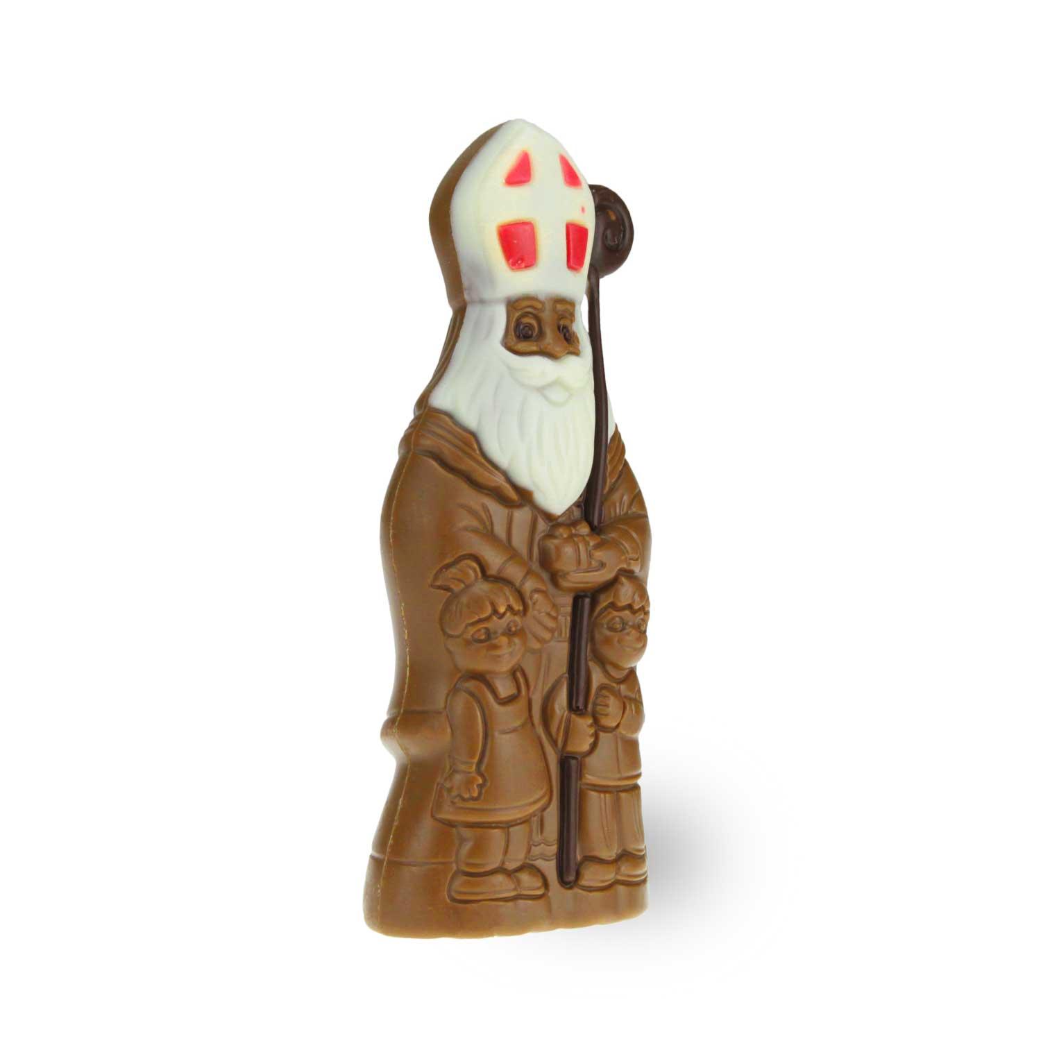 Original Nikolaus aus Schokolade, verziert mit weißer Bischofsmütze und Mantel, Kinderfiguren am Fuß.