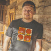 Lächelnder Mann mit Bart und Basecap, trägt ein schwarzes T-Shirt mit vier Pumuckl-Motiven.