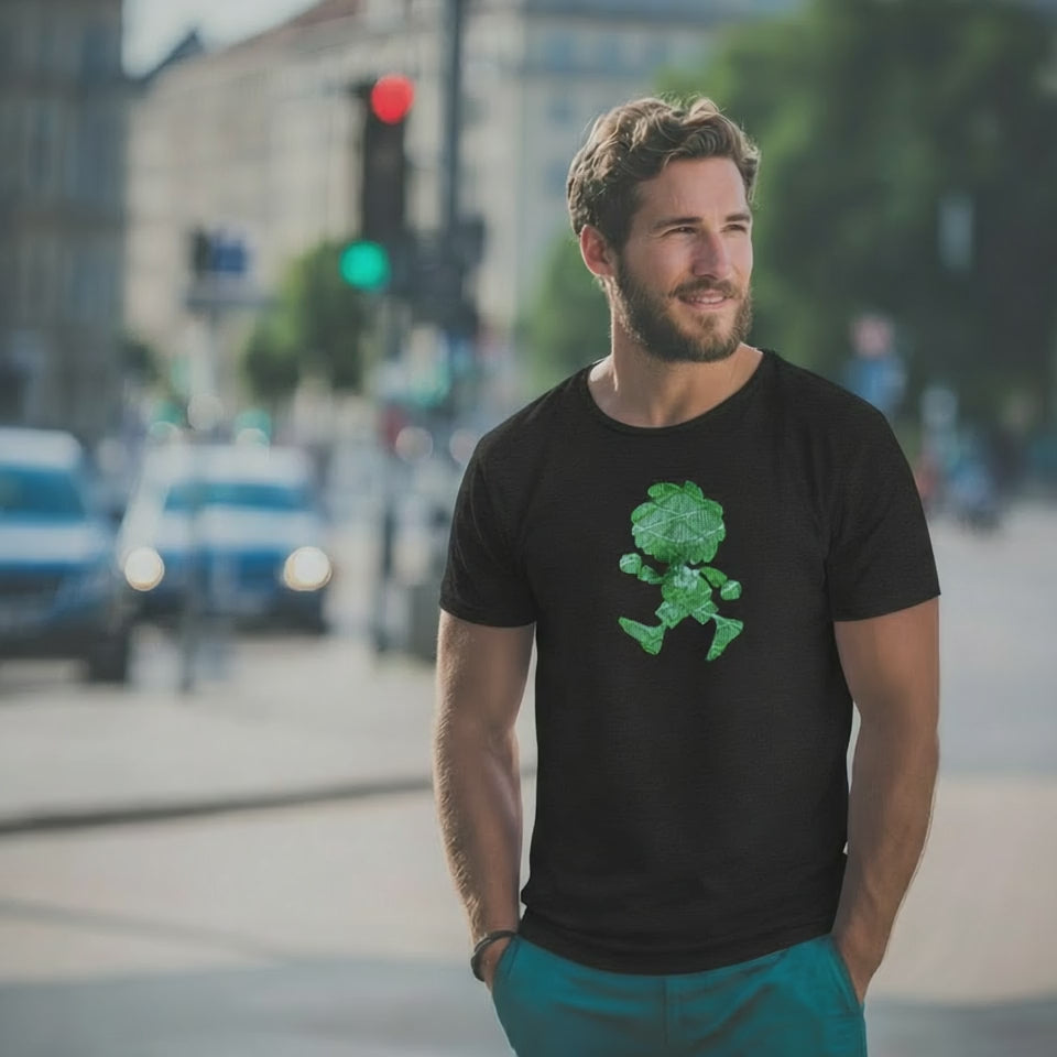 Mann mit Bart trägt schwarzes Pumuckl T-Shirt mit grünem "Ampel-Edition" Motiv auf der Straße.