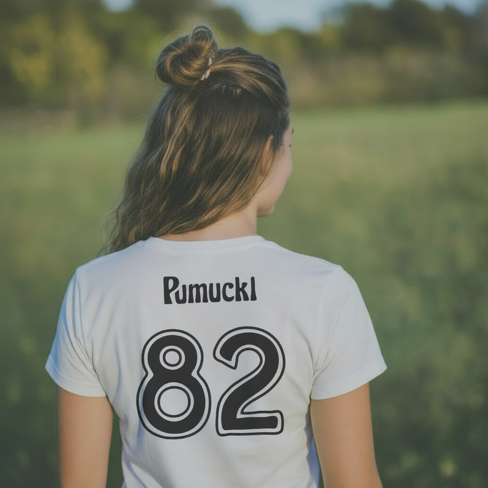 Junge Frau im weißen ®Pumuckl Fußball Kobold T-Shirt mit Aufdruck Pumuckl und 82 auf dem Rücken
