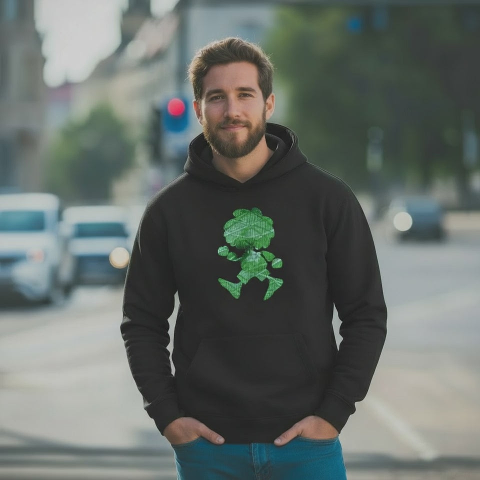 Mann trägt schwarzen ®Pumuckl Hoodie "Ampel-Edition" mit grünem Motiv im urbanen Umfeld