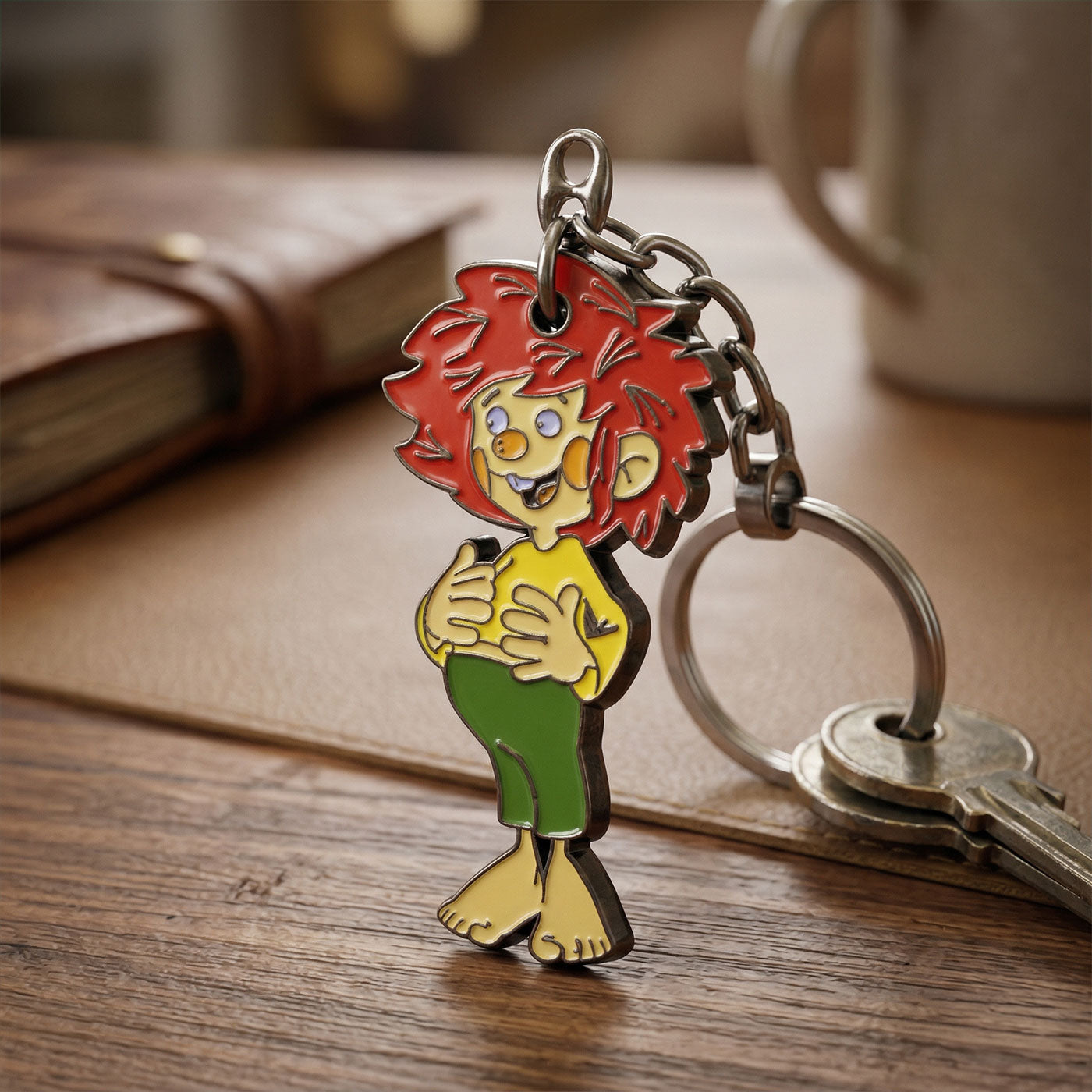 Bunter Pumuckl Schlüsselanhänger mit rotem Haar, gelbem Hemd und grüner Hose auf Holztisch