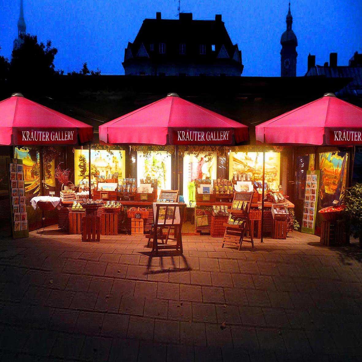 Beleuchtete Marktstände mit roten Vordächern unter dunklem Nachthimmel, bieten Kunsthandwerk und Souvenirs.