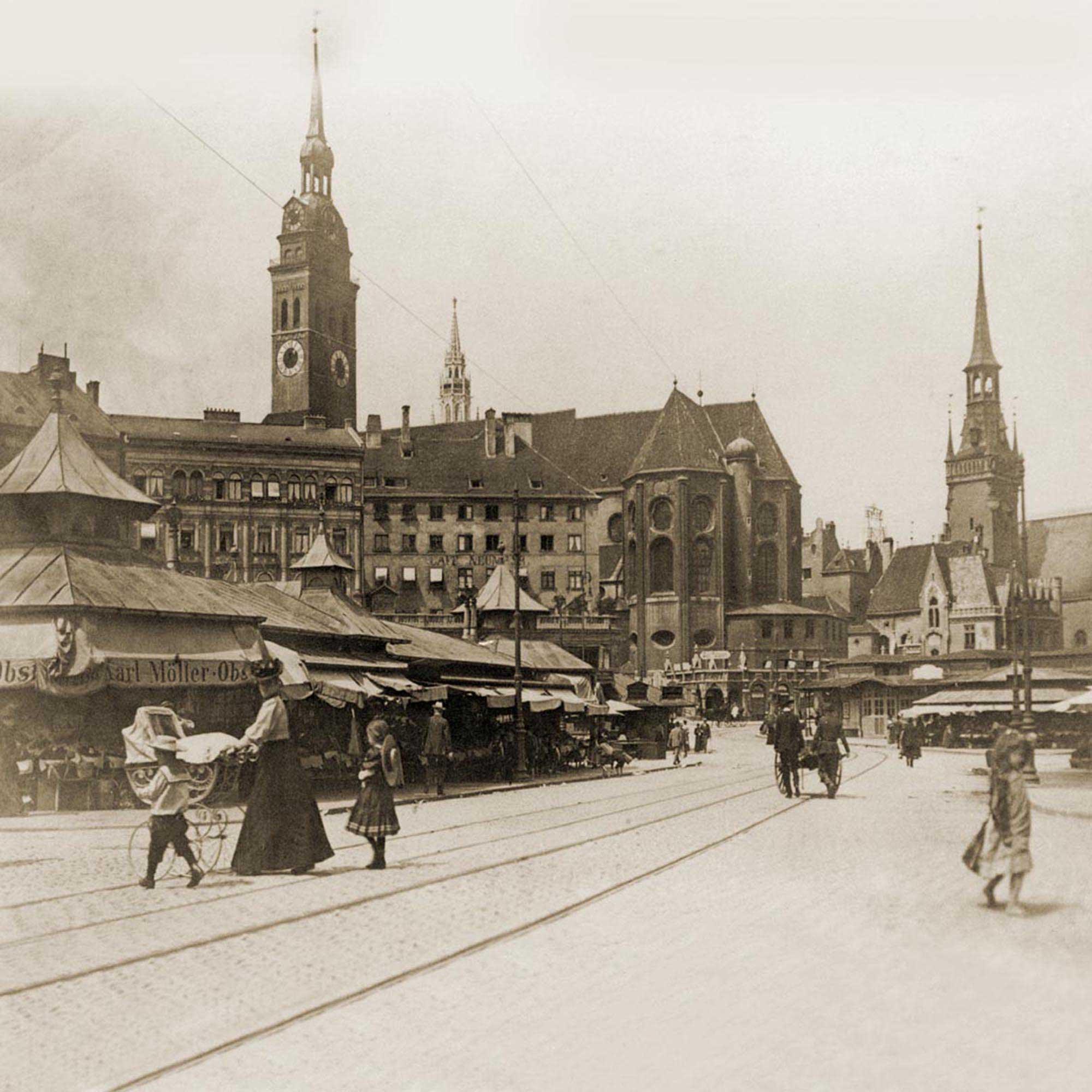 Historischer Marktplatz mit Marktständen, Menschen und Gebäuden mit Spitztürmen, wie eine Kathedrale.