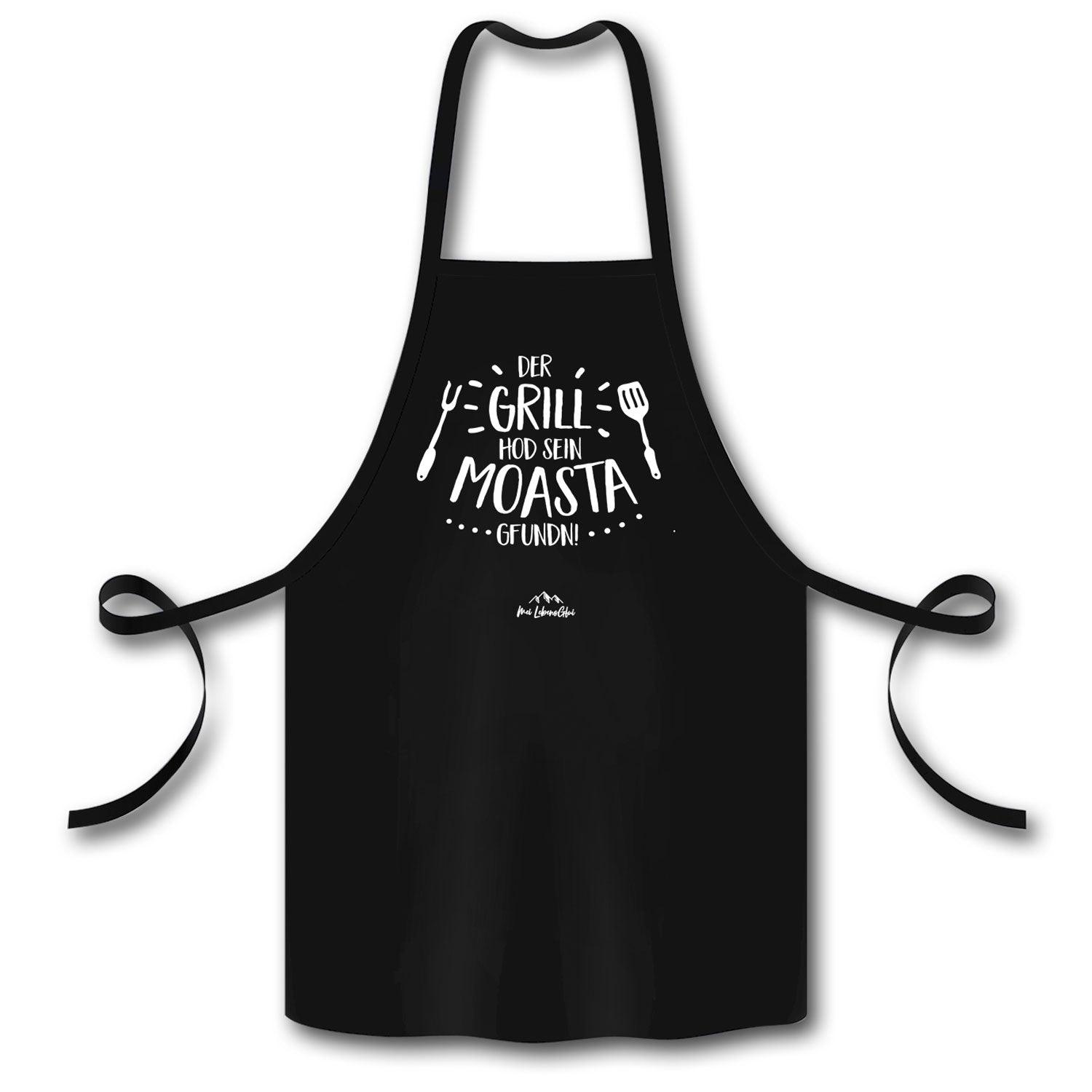 Schwarze Grillschürze Grillmoasta mit weißem Spruch Der Grill hod sein Moasta gfundn und Grillbesteck-Motiv.