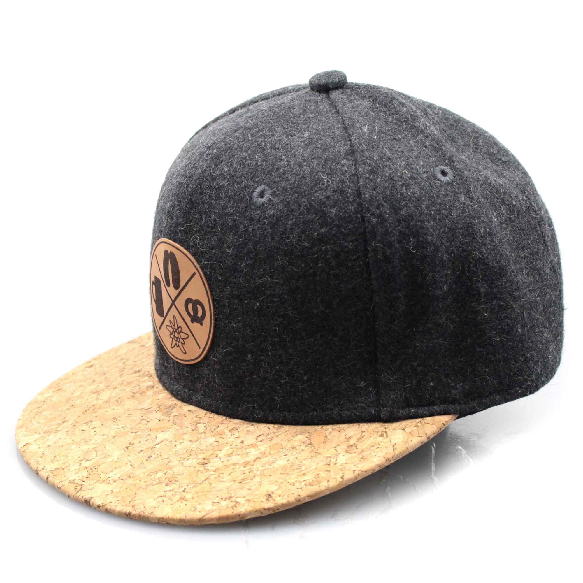 Dunkelgraue Snapback Cap aus Filz mit Kork-Visier und bayerischem Leder-Patch (Brezel, Edelweiß, Masskrug).