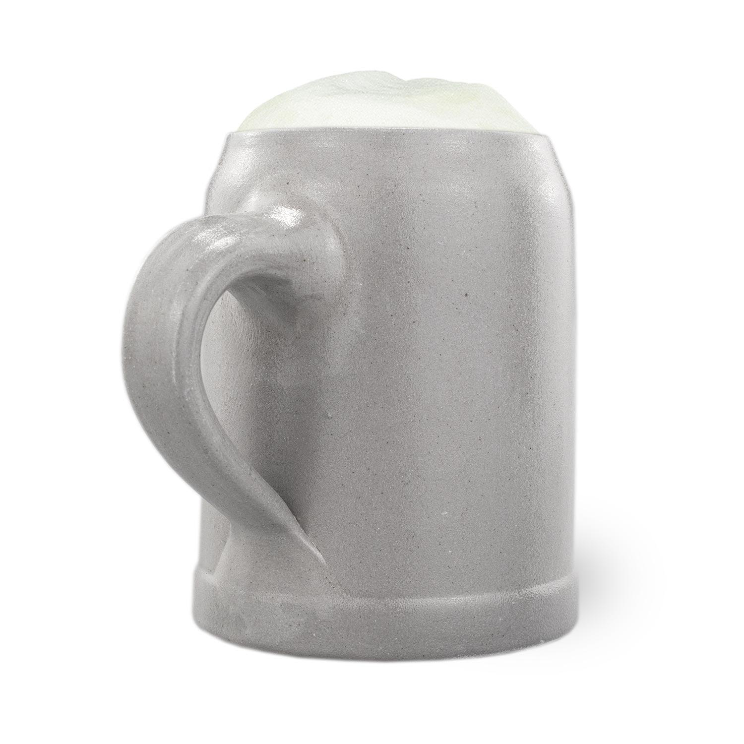 Grauer Steinkrug mit Henkel und Schaumkrone, ideal für Bier und andere Getränke, auf weißem Hintergrund.